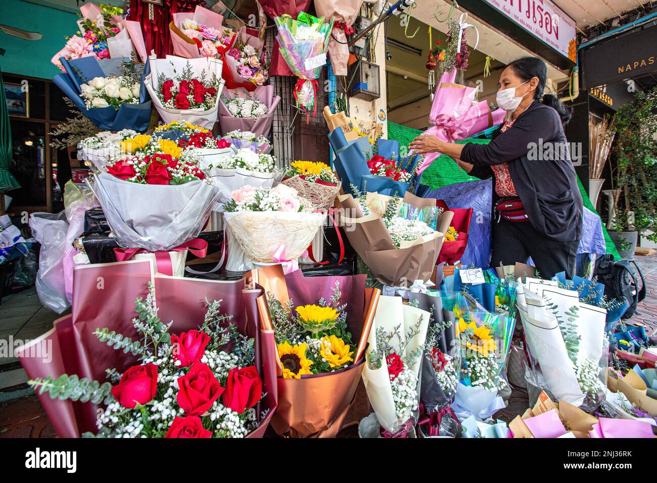 Bangkok, Thailandia. 21st Feb, 2023. Un venditore organizza fiori dalla provincia dello Yunnan del sud-ovest della Cina al mercato dei fiori Pak Khlong Talat a Bangkok, Thailandia, 21 febbraio 2023. L'intensificazione della cooperazione tra Thailandia e Cina nell'ambito dell'iniziativa Belt and Road (BRI) ha beneficiato i commercianti di fiori in entrambi i paesi. I fiori coltivati e raccolti nella provincia dello Yunnan, nel sud-ovest della Cina, possono raggiungere i mercati di Bangkok con trasporto a catena fredda in circa 40 ore. Credit: Wang Teng/Xinhua/Alamy Live News Foto Stock