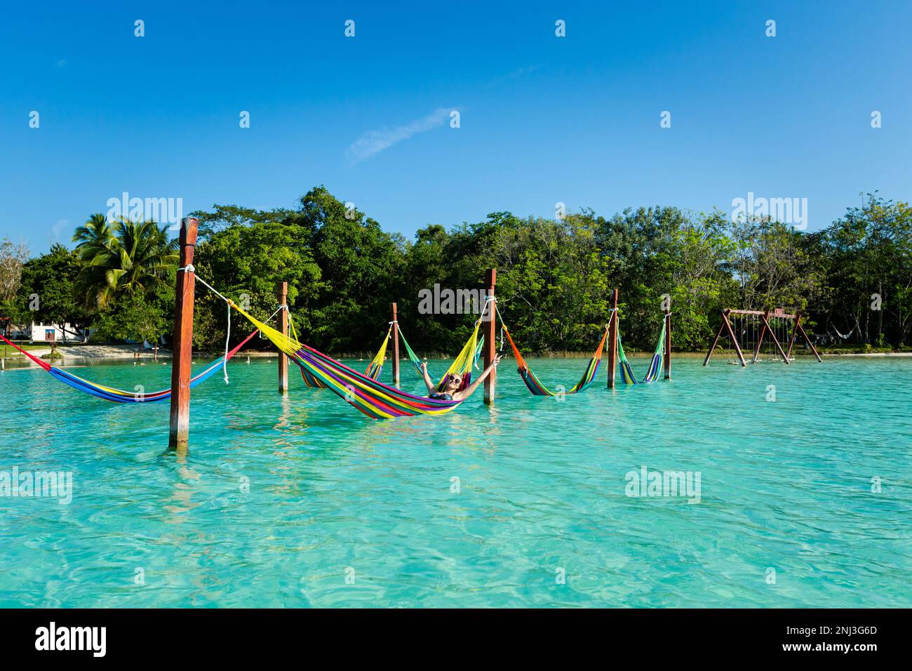 Bella ragazza bianca turista rilassarsi in un'amaca a Laguna Bacalar in Messico durante il viaggio in kayak. Foto Stock