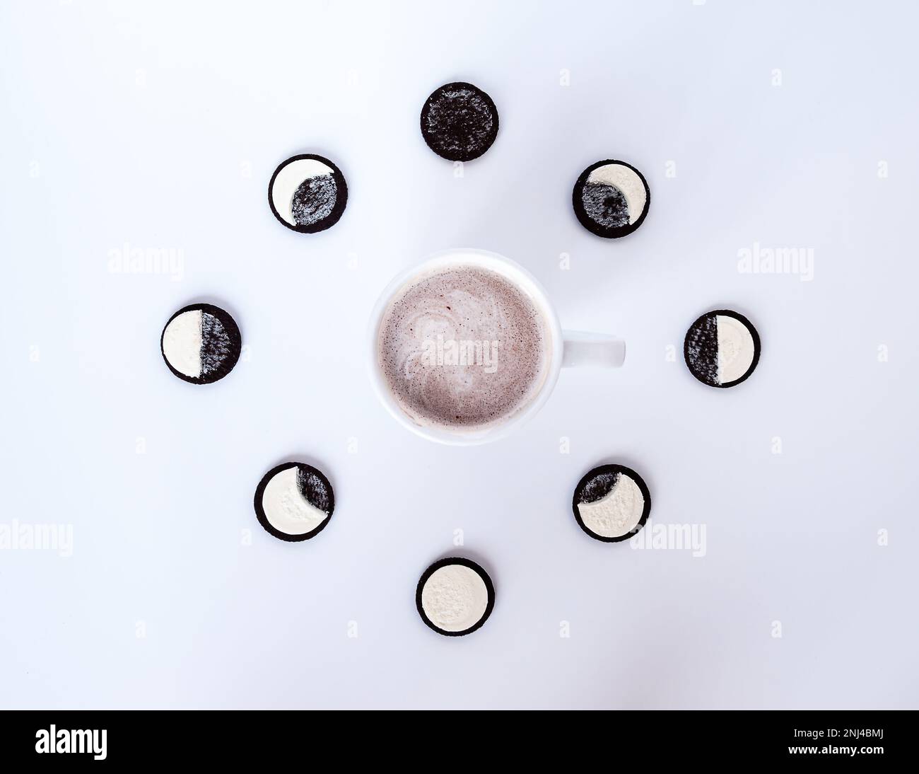 I biscotti al cioccolato sono messi come un orologio con caffè caldo o cacao Foto Stock