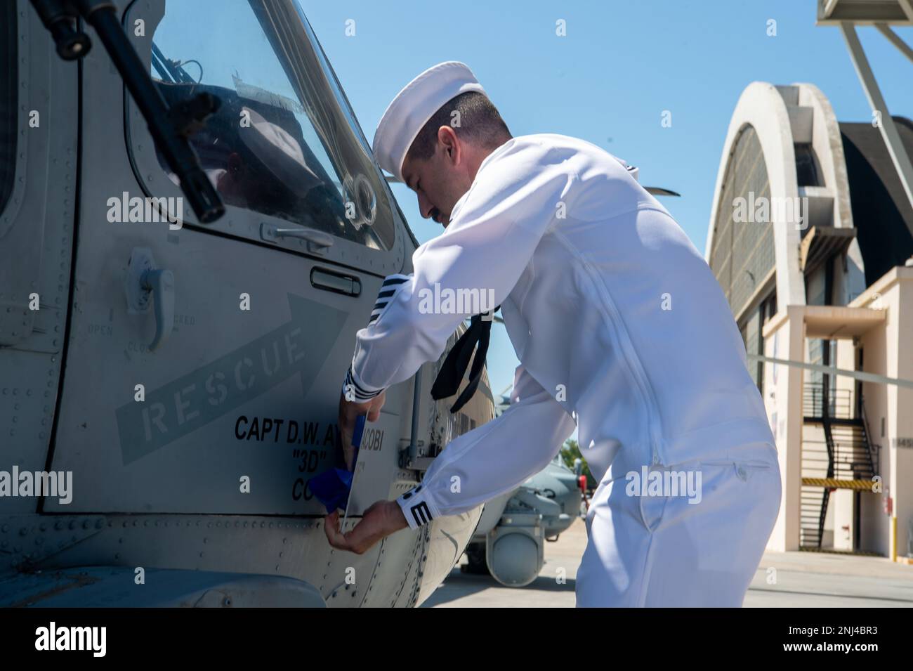 220805-N-EV253-1150 SAN DIEGO (5 agosto 2022) – "frana 04", un elicottero MH-60s Sea Hawk, E velivolo espositore di Helicopter Sea Combat Squadron (HSC) 3, è ridesignato da US Naval Aircrewman 1st Classe Cale Foy durante la cerimonia di cambio di comando dello squadrone tenuto a bordo della Naval Air Station (NAS) North Island a Coronado, California, 5 agosto. Durante la cerimonia, CMdR. Loren Jacobi fu sollevato dal capitano David Ayotte, che divenne il 46th comandante ufficiale a guidare i 'Merlins' di HSC-3. HSC-3 è lo squadrone di sostituzione della flotta della Marina MH-60s, responsabile della formazione dei piloti e dell'airc Foto Stock