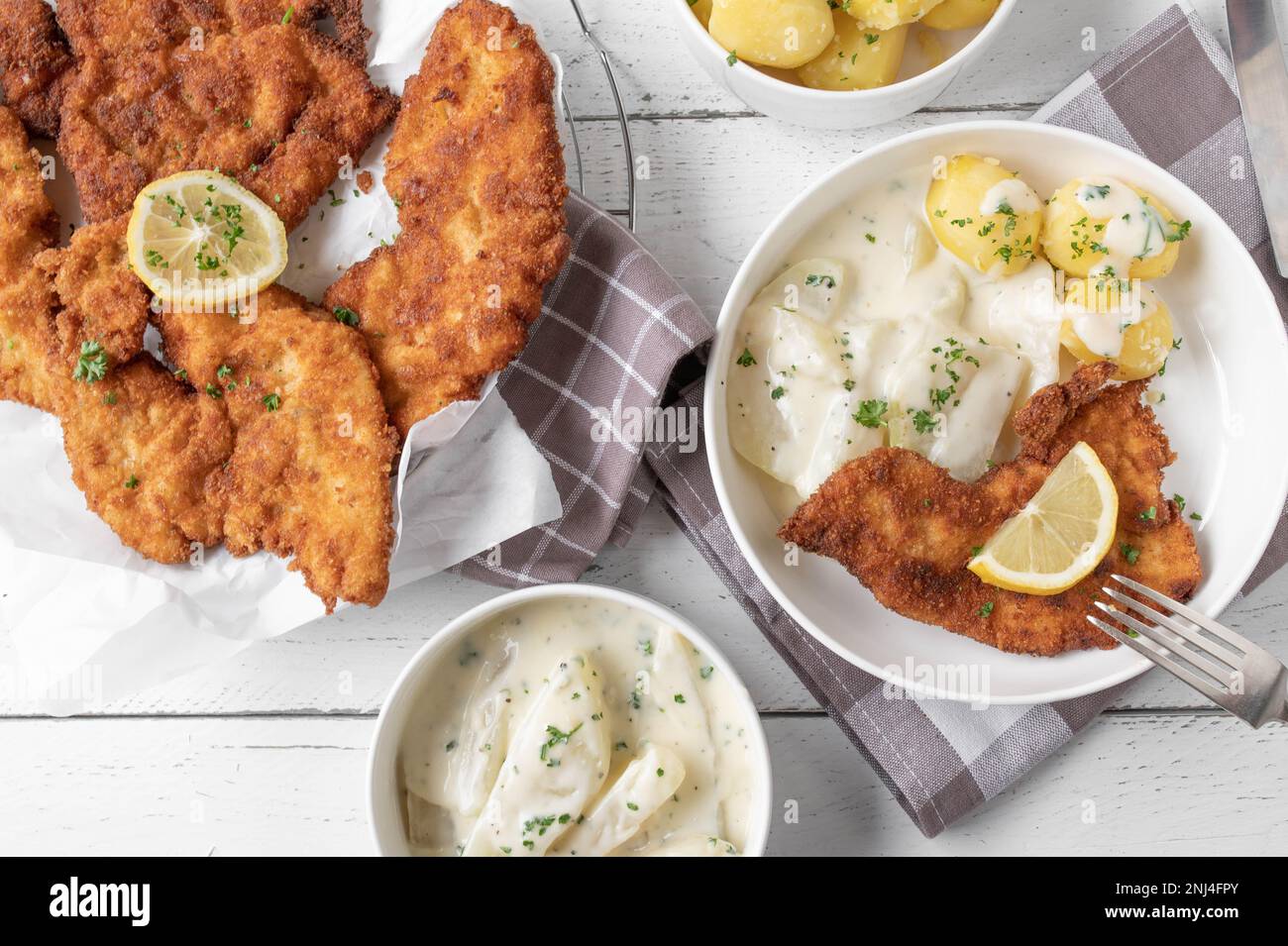 Schnitzel con salsa di bechamel kohlrabi e patate bollite sul tavolo da cucina Foto Stock