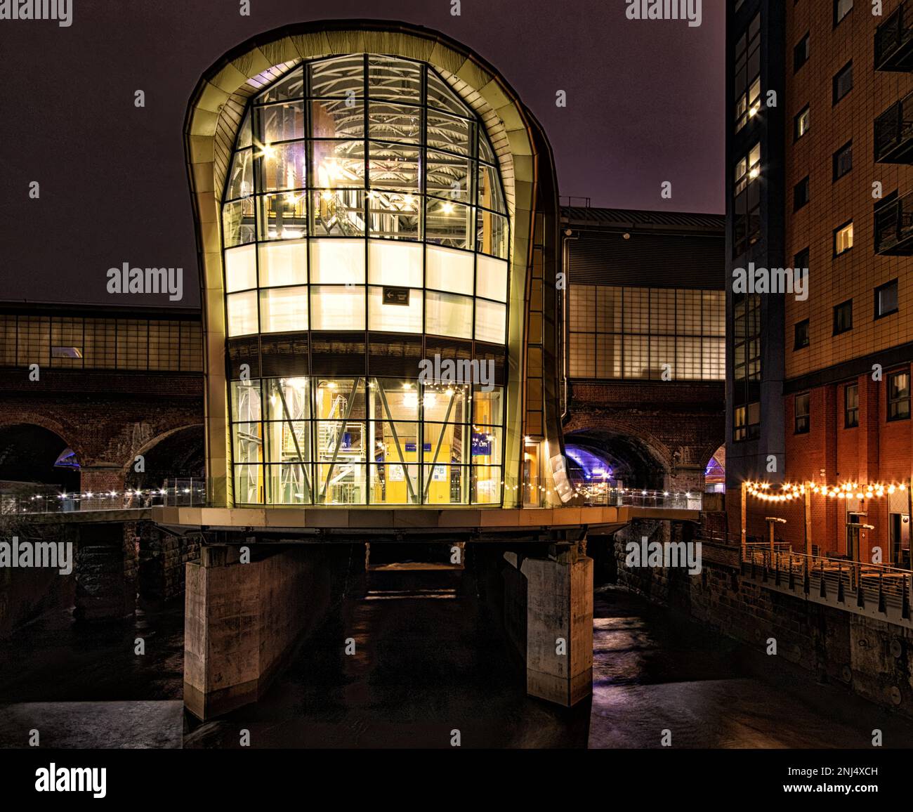 Una facciata illuminata di notte vicino alla Stazione Centrale di Leeds, in Granary Wharf Foto Stock