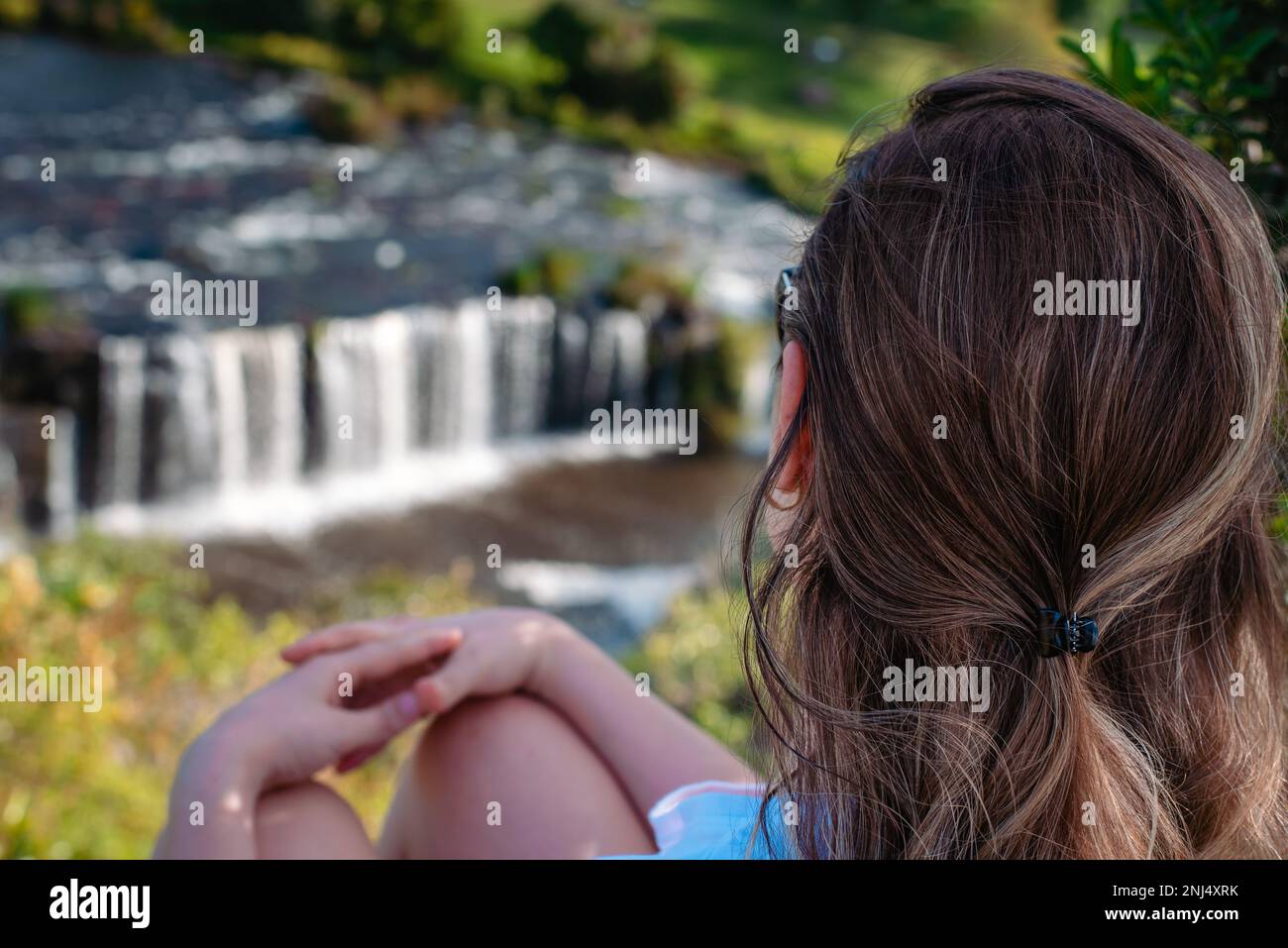 donna alle cascate che ammirano il panorama Foto Stock