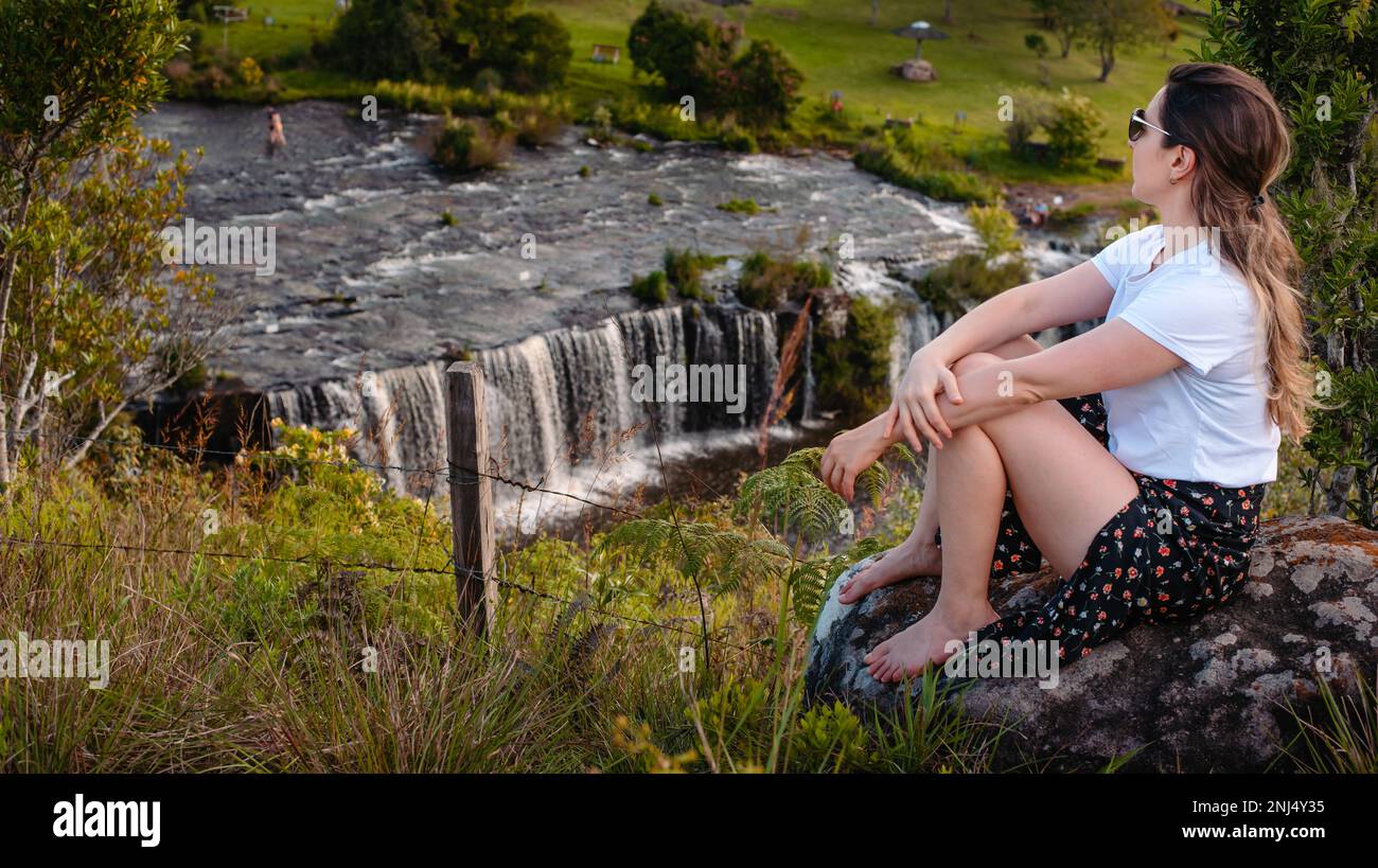 donna alle cascate che ammirano il panorama Foto Stock