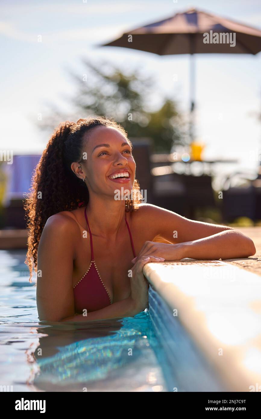Donna sorridente in vacanza estiva relax in piscina Foto Stock
