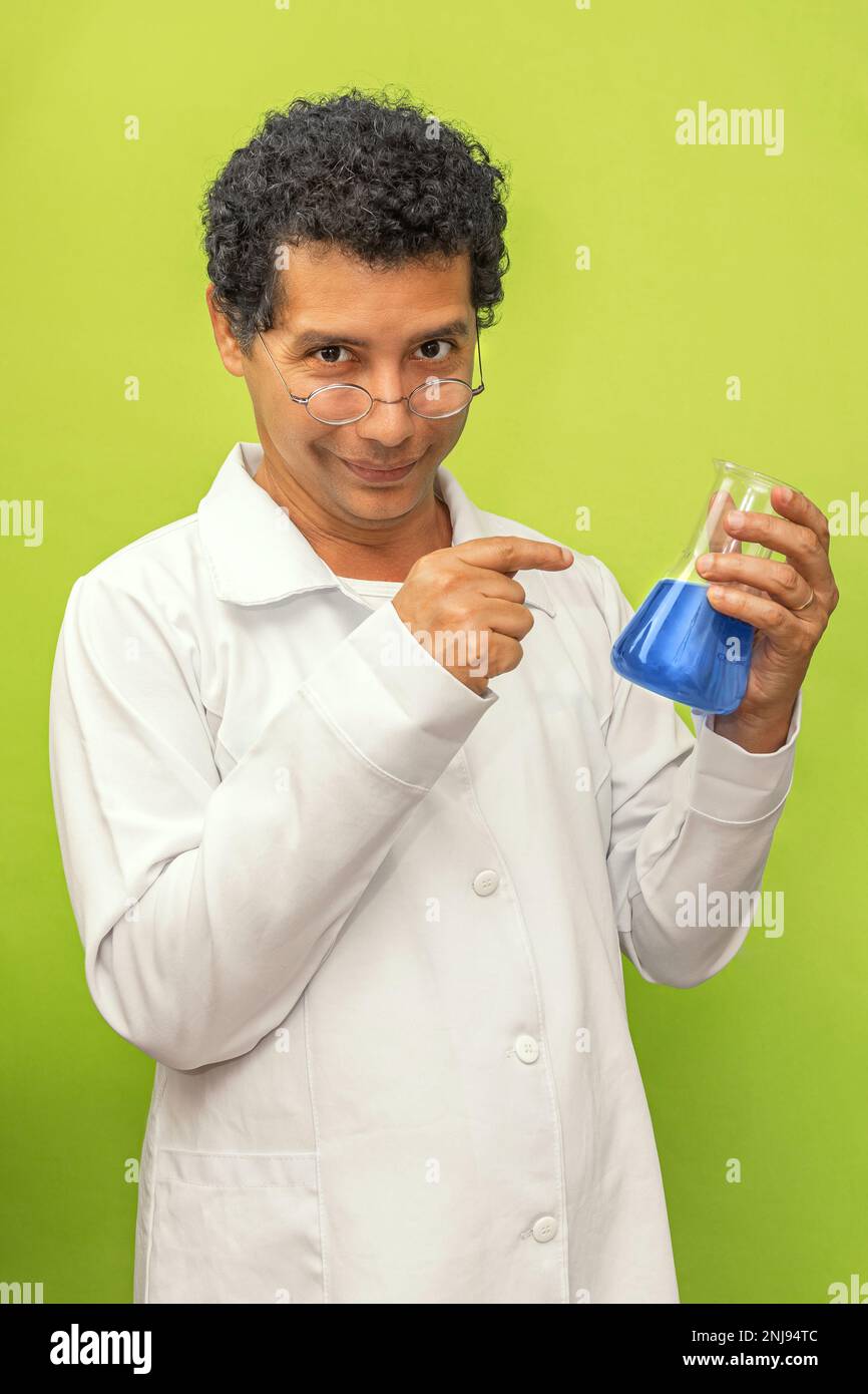 Ritratto di uno scienziato genio brasiliano felice con il suo esperimento scientifico su sfondo verde, medico con cappotto bianco Foto Stock