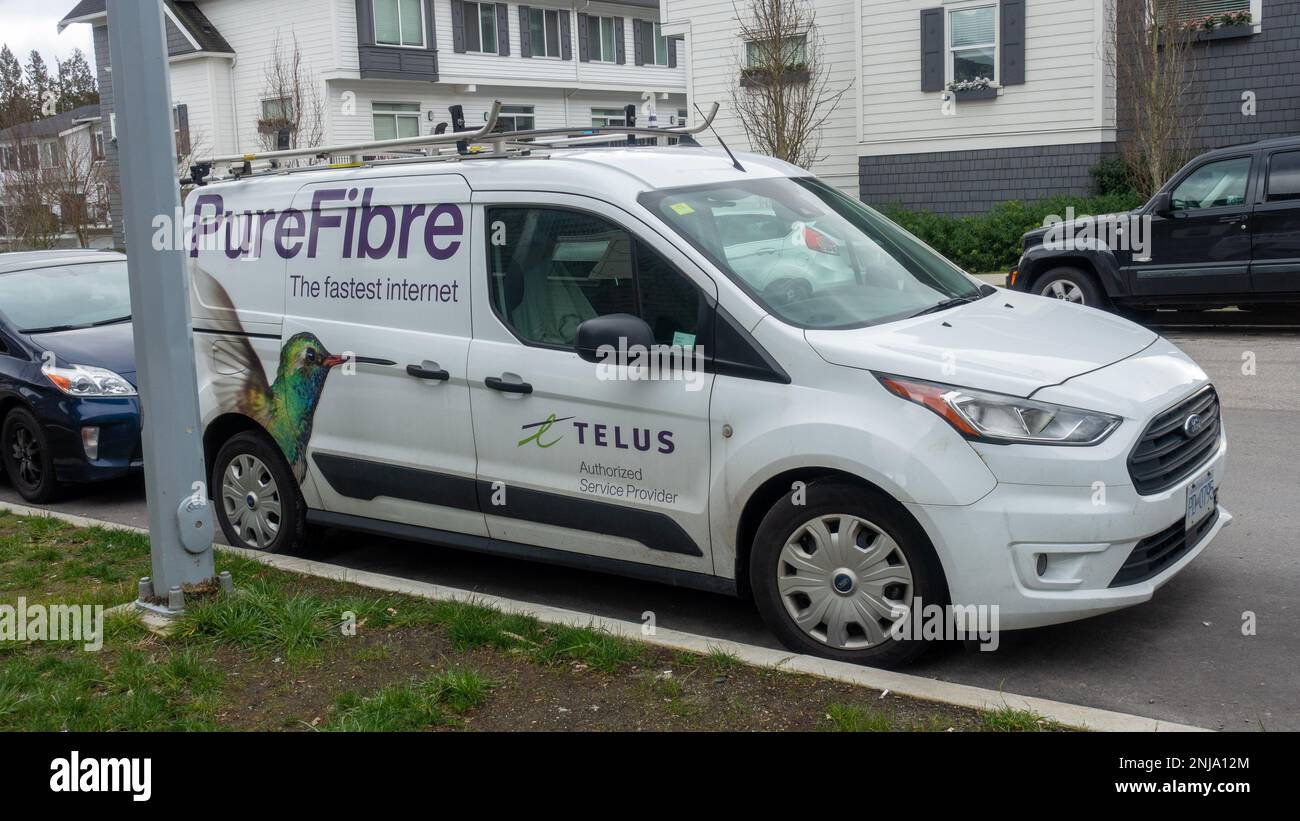 Surey BC, Canada - 21 febbraio 2023: Un furgone Ford Transit bianco per TELUS PureFibre Internet, con un'importante grafica di colibrì. Foto Stock
