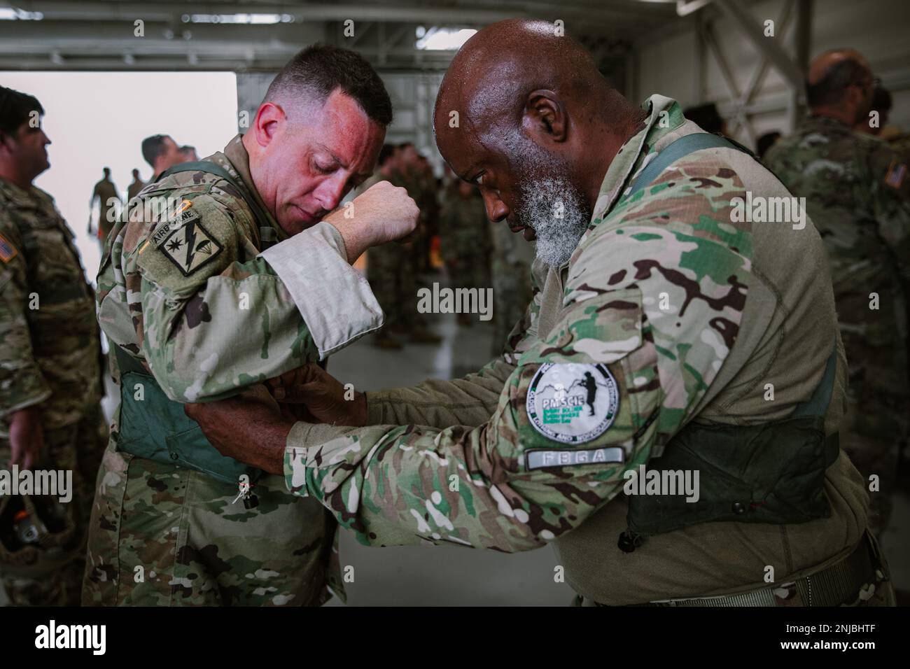 STATI UNITI L'esercito e i paracadutisti internazionali si preparano a mettere i loro paracadute MC-6 durante il Leapfest 2022 presso la struttura di supporto dell'aviazione militare di Quonset nella contea di Washington, Rhode Island, il 6 agosto 2022. Leapfest è il più grande evento e concorso internazionale per l'addestramento del paracadute statico di lunga data, organizzato dal comando della truppa del 56th, dalla Guardia nazionale dell'esercito del Rhode Island, per promuovere la formazione tecnica di alto livello e l'esprit de Corps all'interno della comunità internazionale di Airborne. Foto Stock