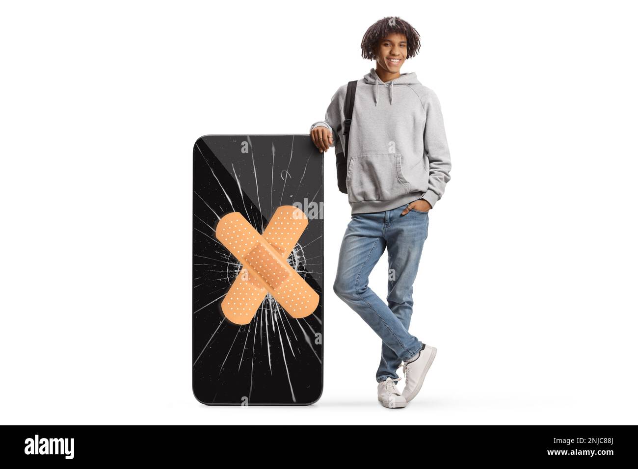 Giovane afro-americano con un grande telefono cellulare con schermo incrinato e bendaggio isolato su sfondo bianco Foto Stock