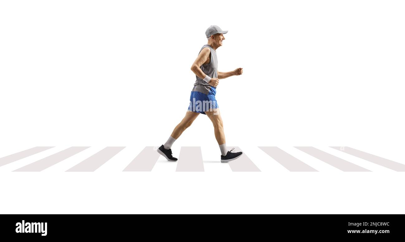 Foto a profilo completo di un uomo anziano che fa jogging su un passaggio pedonale isolato su sfondo bianco Foto Stock