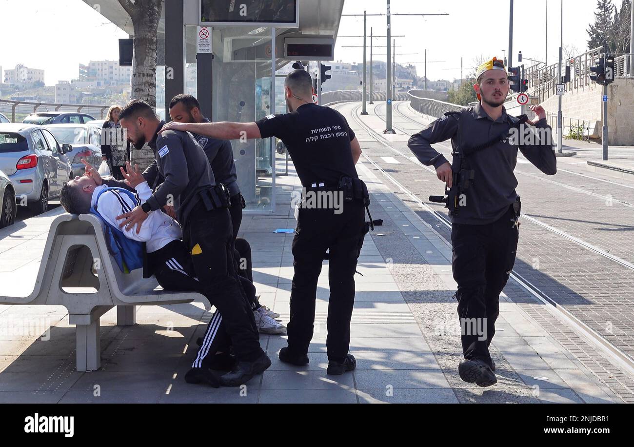 GERUSALEMME, ISRAELE - 22 FEBBRAIO: Le guardie di sicurezza della ferrovia leggera trattengono un giovane palestinese dopo averlo rimosso dalla macchina del treno, in una stazione del tram nel quartiere di Gerusalemme est di Beit Hanina il 22 febbraio 2023, a Gerusalemme, Israele. Alla luce dell'attuale ondata di attentati terroristici a Gerusalemme, il governo israeliano ha deciso di rafforzare le forze di sicurezza e di migliorare la sicurezza personale nella città. Tre compagnie di polizia di frontiera sono state mobilitate a Gerusalemme est a causa della crescente violenza nei quartieri palestinesi. Credit: Eddie Gerald/Alamy Live News Foto Stock