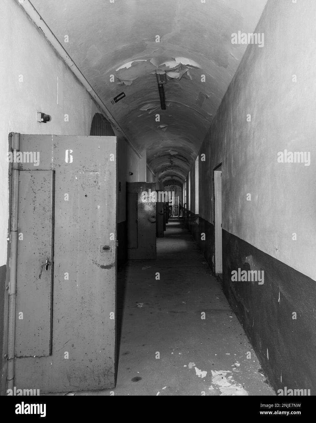 corridoio di una prigione abbandonata, le celle della porta sono aperte, arrugginite e luogo di decadimento Foto Stock