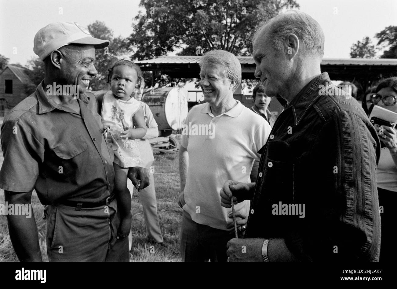 1976 candidato democratico alla presidenza Jimmy carter nella sua fattoria in pianura, GA. Carter sta parlando con l'ex astronauta e con il senatore americano John Glenn circa la possibilità che Glenn diventi il compagno di corsa vicepresidenziale del carter. Carter e Glenn incontrano carter, contadino afro-americano Leonard Wright e sua figlia. Foto Stock