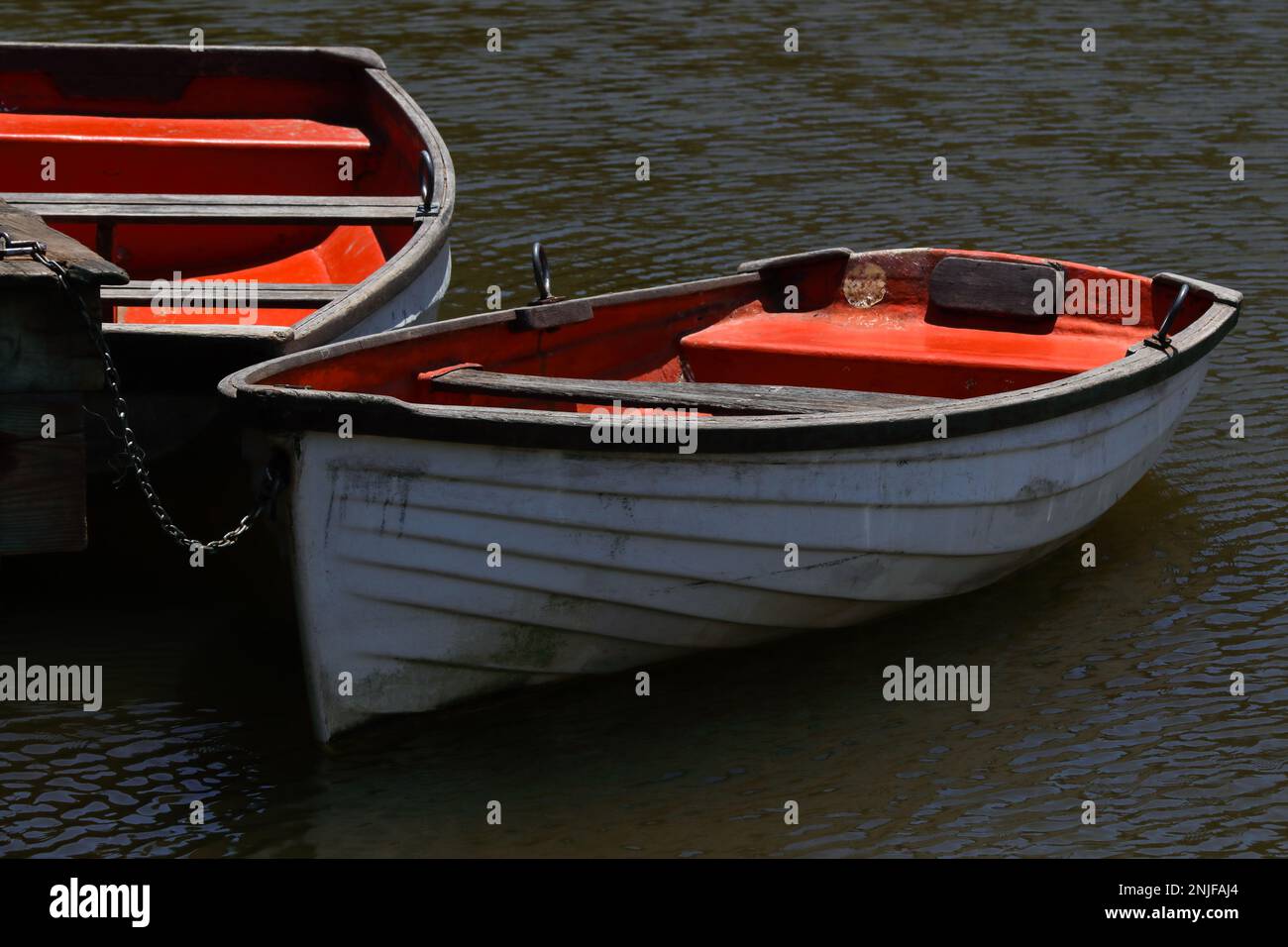Barche a remi legate al Molo del Lago di legno Foto Stock