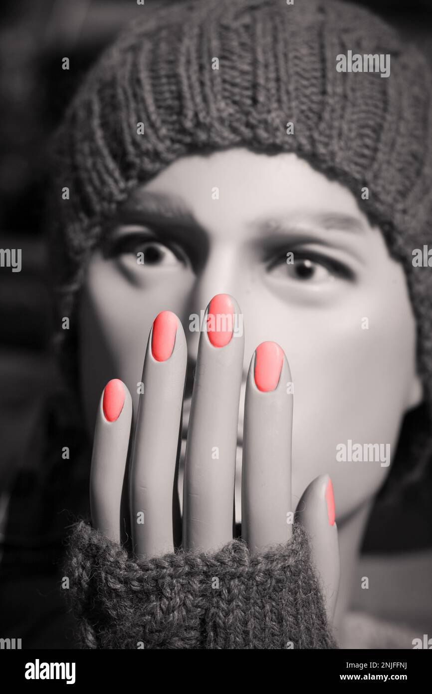 Foto in bianco e nero di una testa di manichino con smalto per unghie rosso Foto Stock