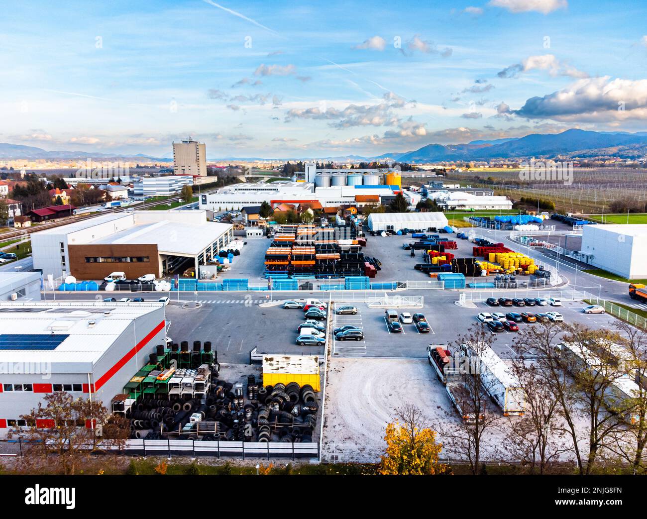 Un lotto di fabbrica con alcuni camion e magazzino all'aperto, fuco sparato Foto Stock