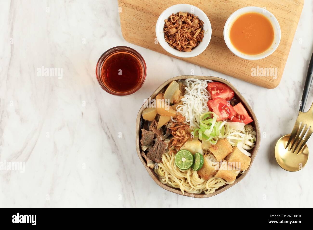 Soto mie Bogor, zuppa di manzo trasparente con noodle e rotolo primaverile. Vista superiore con spazio di copia per testo o ricetta Foto Stock