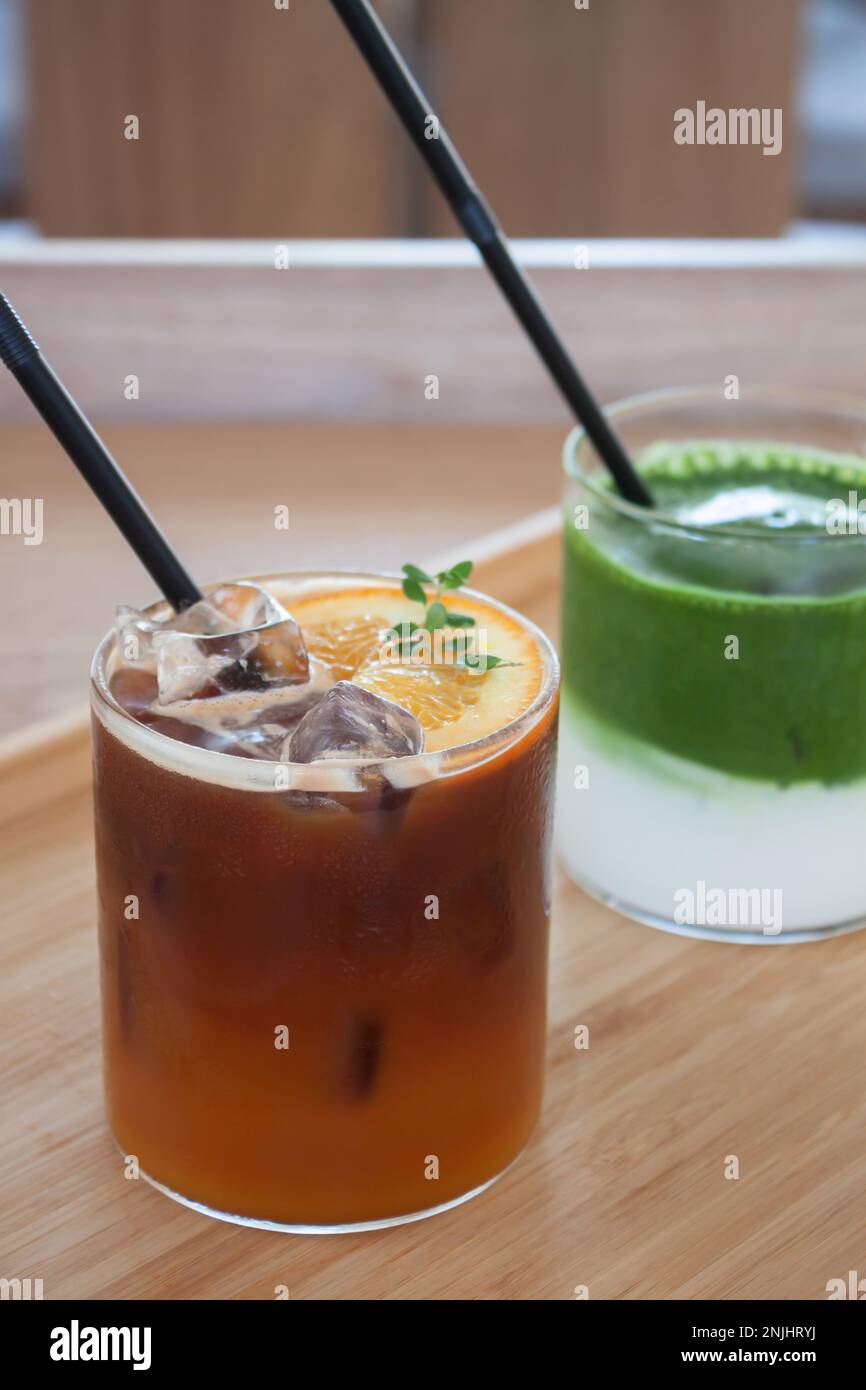 Americano ghiacciato con tè verde matcha arancione e ghiacciato nella caffetteria, foto di scorta Foto Stock