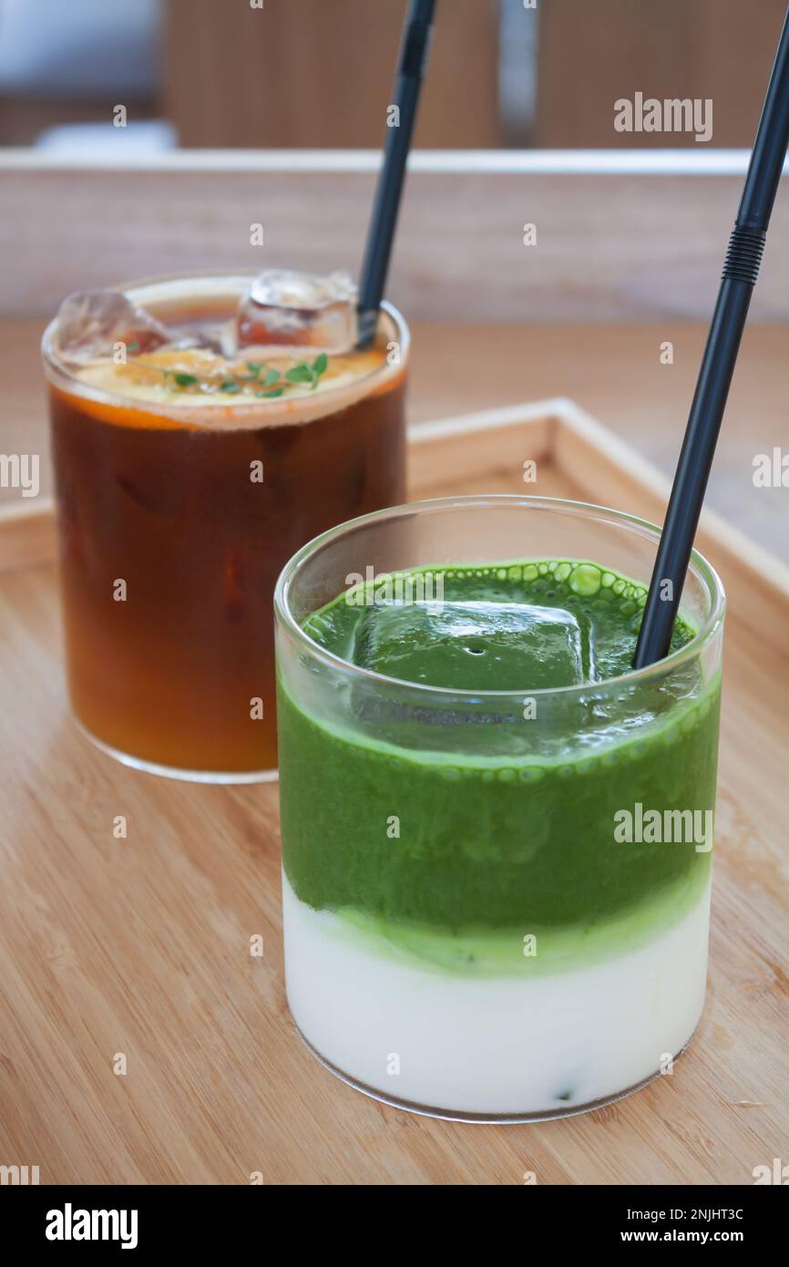 Americano ghiacciato con tè verde matcha arancione e ghiacciato nella caffetteria, foto di scorta Foto Stock