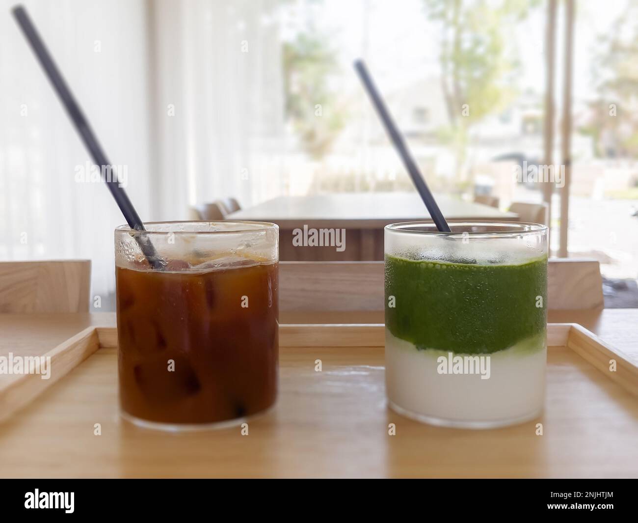 Americano ghiacciato con tè verde matcha arancione e ghiacciato nella caffetteria, foto di scorta Foto Stock