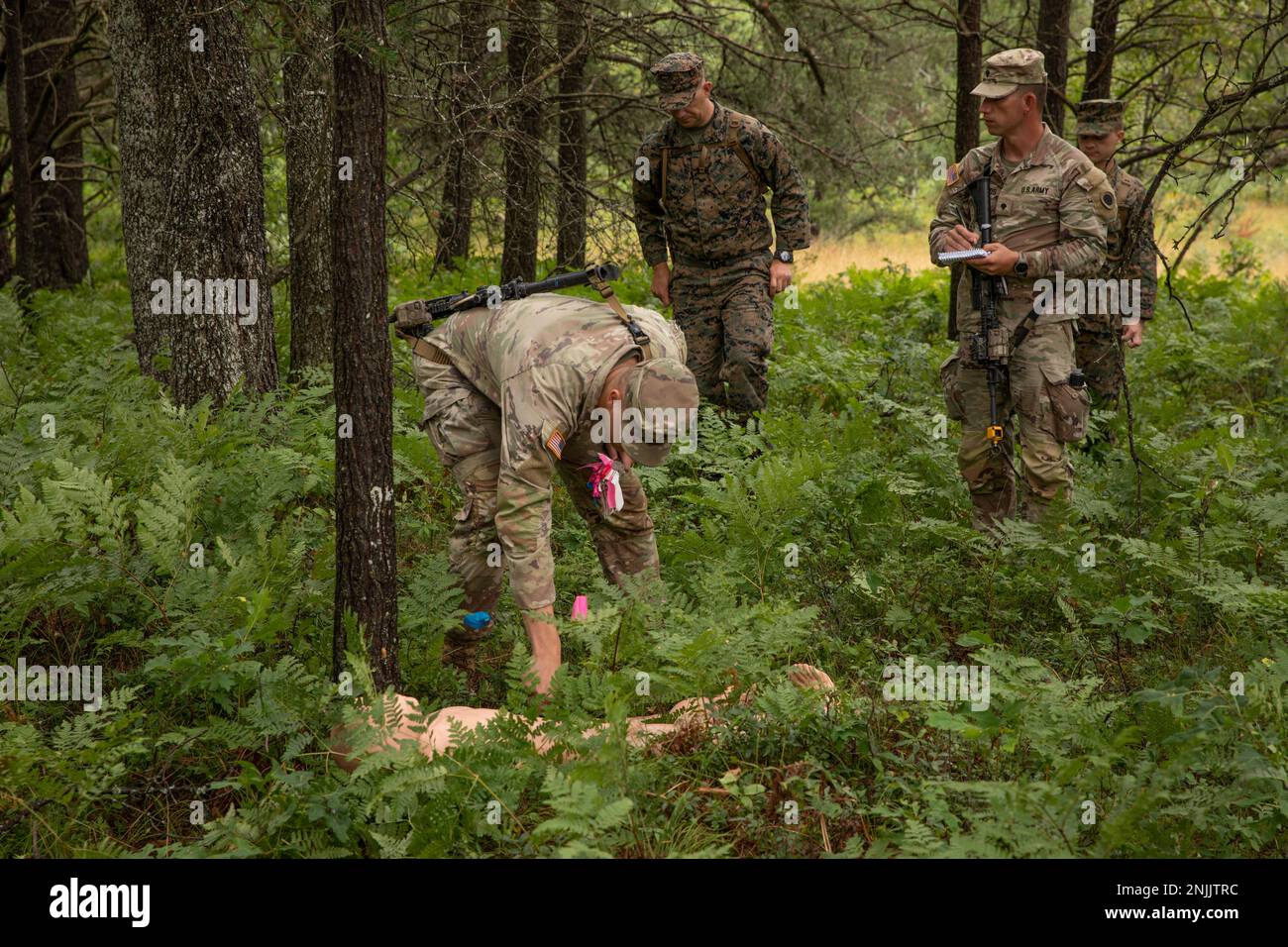 I soldati assegnati a Bravo Company, 1st battaglione, 125th reggimento fanteria, Michigan National Guard, collocano i marcatori intorno a un corpo di manichino durante la loro attività di ricerca e recupero guidata dagli Stati Uniti Sean Whelan Combat Logistics Regiment 45, Personnel Retrieval and Processing Company (-) at Northern Strike 22-2 in Grayling, Michigan, 8 agosto 2022. Northern Strike si concentra sulla capacità delle forze armate di addestrare il combattente in qualsiasi ambiente attraverso il continuum in modo che la nostra nazione possa competere, scoraggiare e vincere oggi e domani. Foto Stock