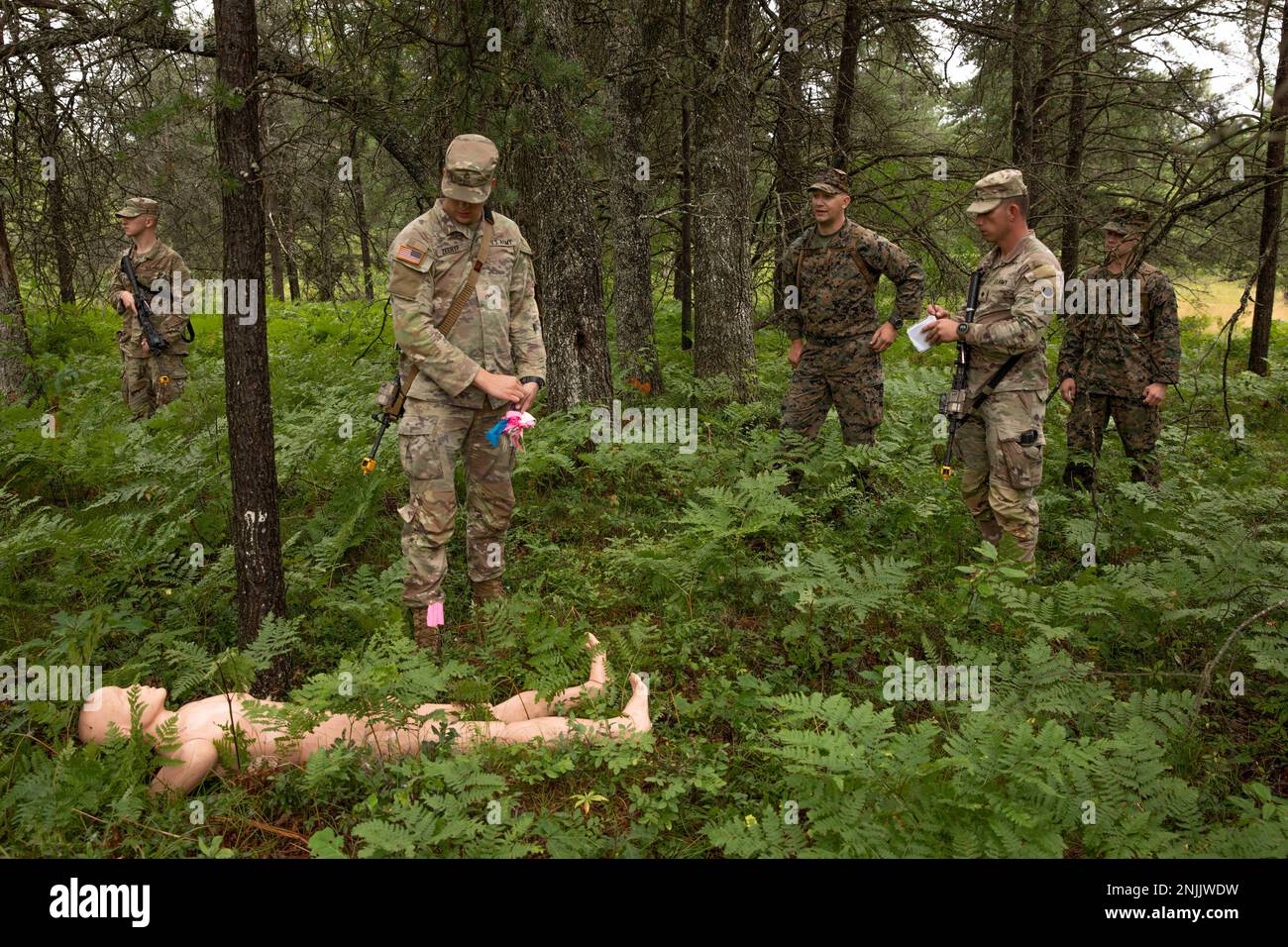 Soldiers to Bravo Company, 1st Battaglione, 125th Regimento della Fanteria, Michigan National Guard, posiziona dei pennarelli intorno a un corpo di manichino durante l'esercizio di ricerca e recupero condotto dagli Stati Uniti Sean Whelan Combat Logistics Regiment 45, Personnel Retrieval and Processing Company (-) at Northern Strike 22-2 in Grayling, Michigan, 8 agosto 2022. Northern Strike si concentra sulla capacità delle forze armate di addestrare il combattente in qualsiasi ambiente attraverso il continuum in modo che la nostra nazione possa competere, scoraggiare e vincere oggi e domani. Foto Stock