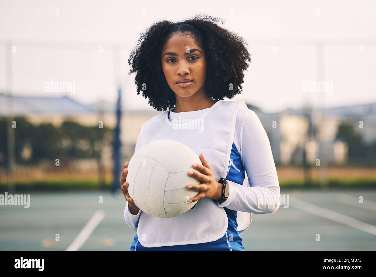 Sport, netball e ritratto di una donna con una palla dopo una partita, esercizio fisico o allenamento in campo. Fiducia, fitness e atleta capitano femminile Foto Stock