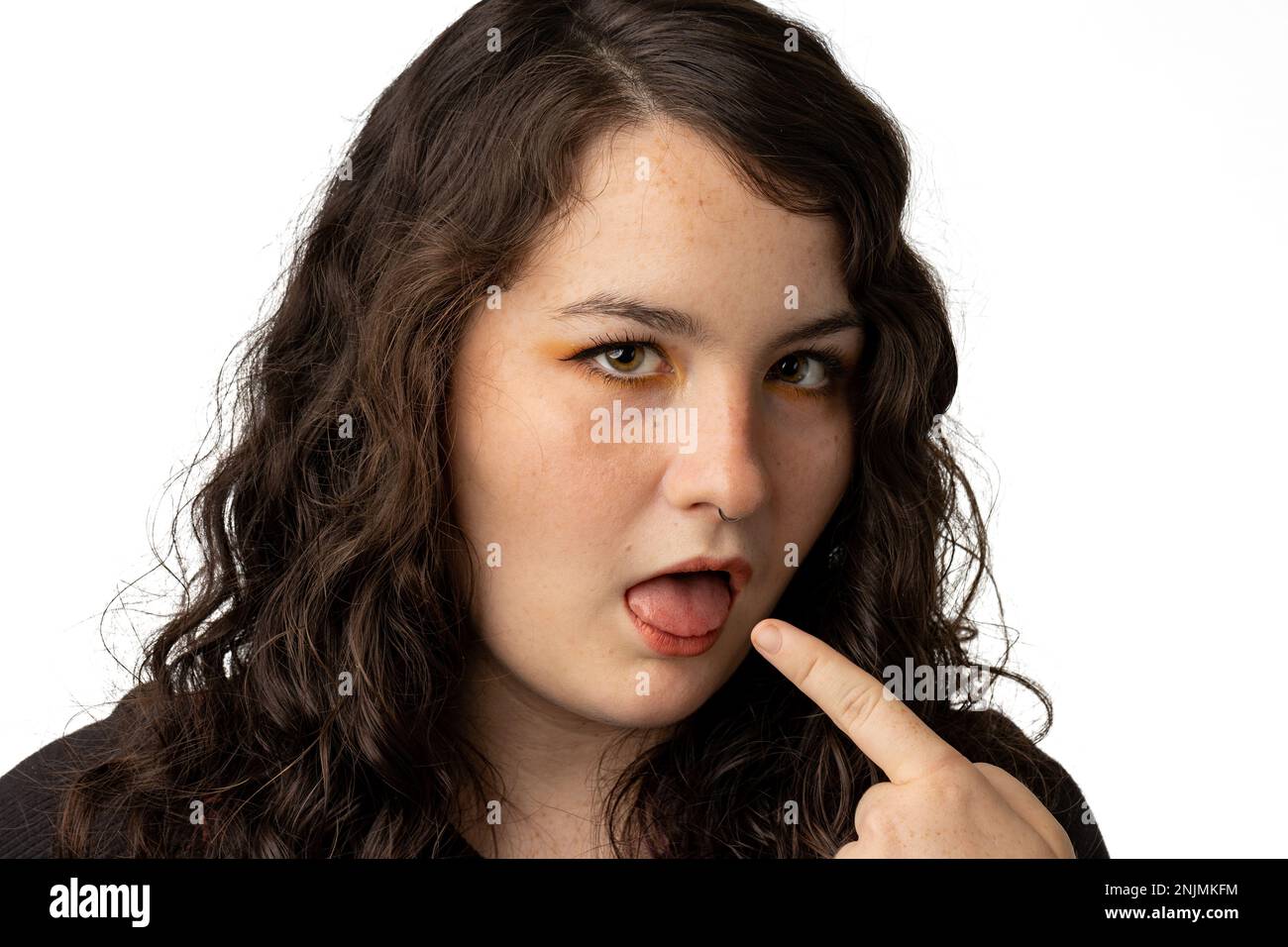 Primo piano della giovane donna che fa un volto di disapprovazione, sfondo bianco. Foto Stock