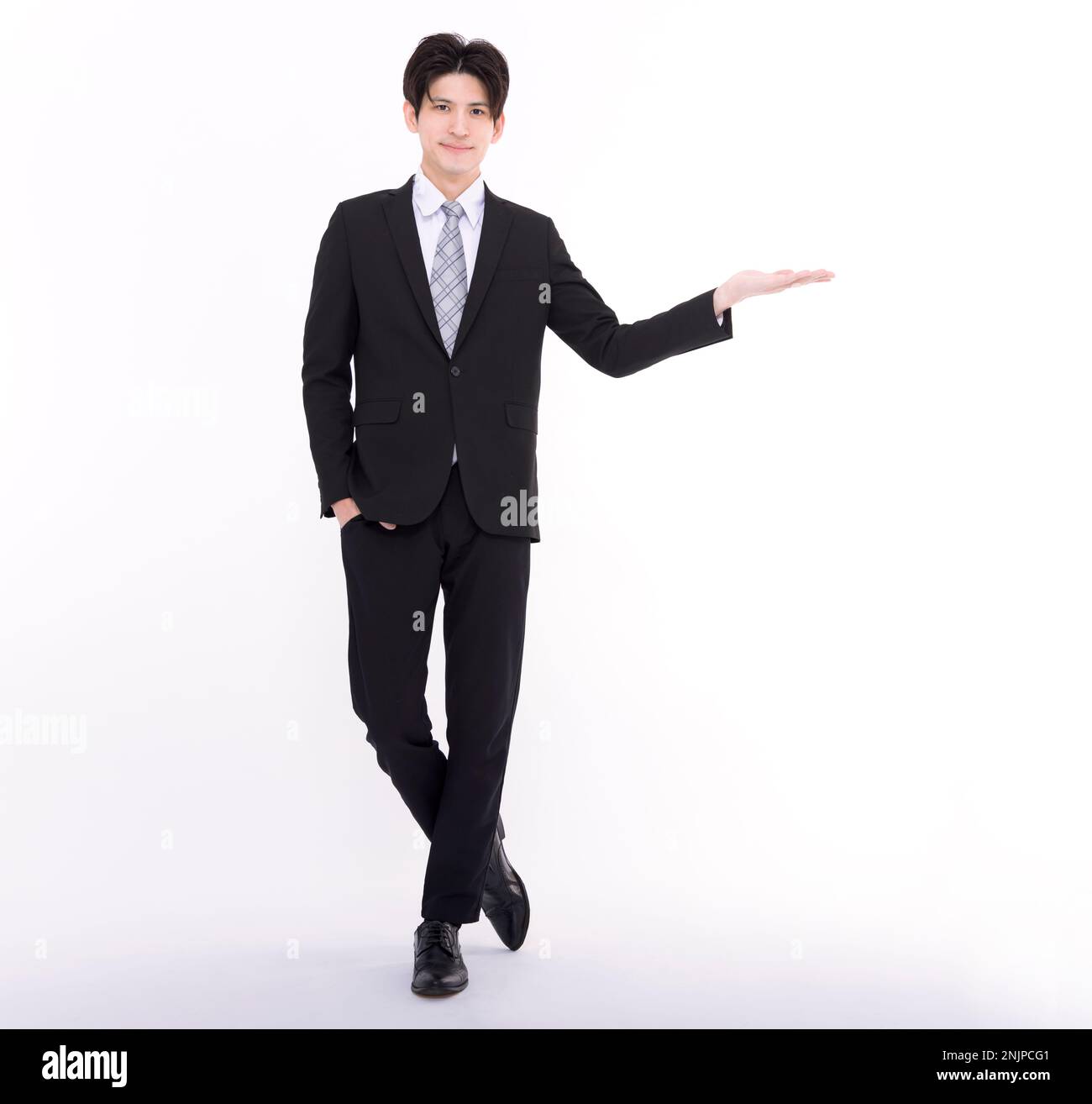 Il giovane uomo d'affari asiatico presenta qualcosa di isolato su sfondo bianco. Foto Stock