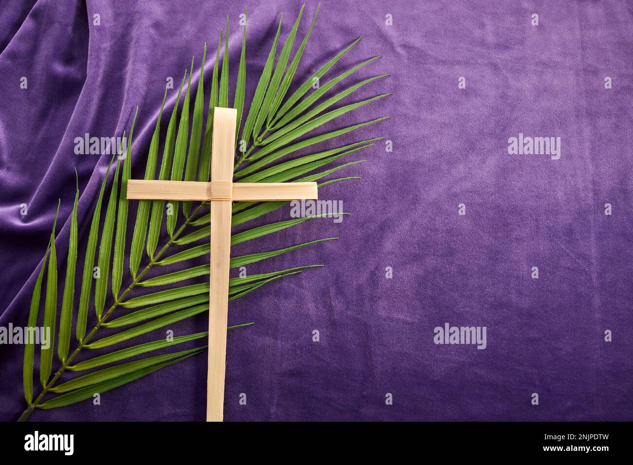 Tempo di Quaresima, settimana Santa e venerdì Santo. Lascia il palmo e croce su sfondo viola Foto Stock