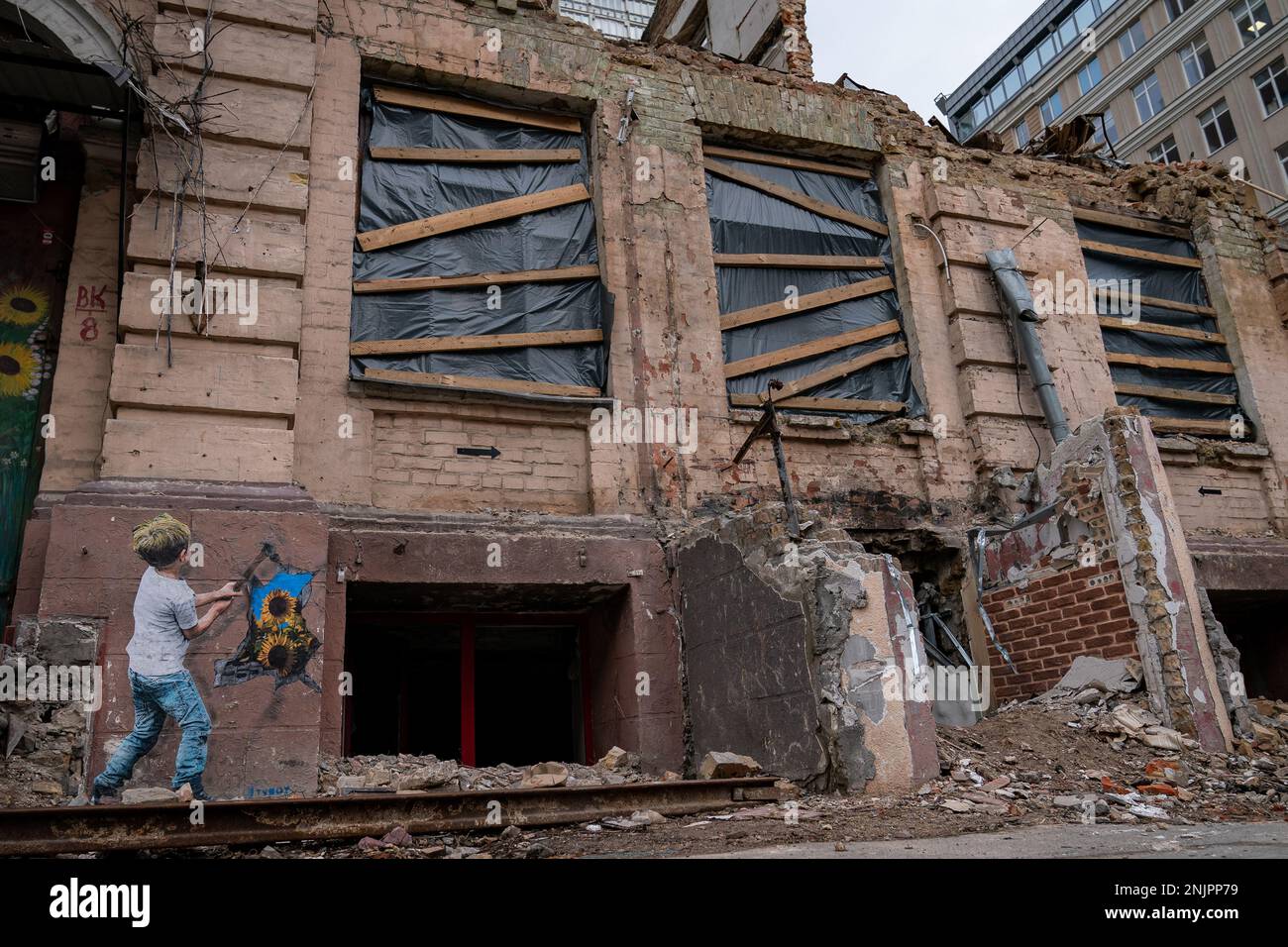 Opere d'arte dipinte su un blocco di appartamenti danneggiato vicino alla torre degli affari a Kyiv, in vista del primo anniversario il Venerdì dell'invasione russa dell'Ucraina. Data immagine: Mercoledì 22 febbraio 2023. Foto Stock