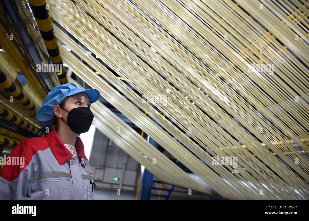 Xining, la provincia cinese di Qinghai. 22nd Feb, 2023. Un membro dello staff controlla i filamenti grezzi presso la base di produzione di Zhongfu Shenying Carbon Fiber Co., Ltd. A Xining, provincia Qinghai della Cina nord-occidentale, 22 febbraio 2023. Le linee di produzione dell'azienda sono in funzione 24 ore su 24 per soddisfare la domanda dei suoi clienti, e circa il 80% della capacità di produzione annuale dei suoi impianti di prima fase sono già stati prenotati finora. Credit: WU Gang/Xinhua/Alamy Live News Foto Stock