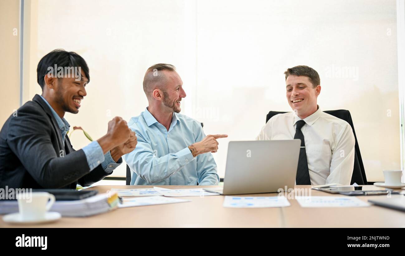 Un allegro team finanziario è in riunione, si sente soddisfatto della situazione finanziaria attuale della loro azienda e festeggia il successo insieme. Foto Stock
