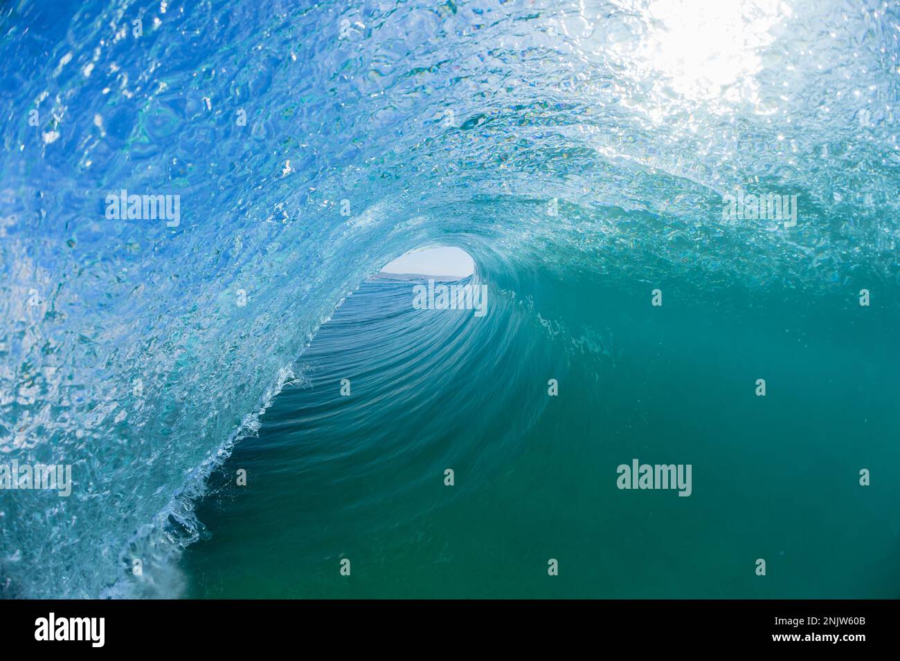 Onde oceano nuoto all'interno di tubing cavo acqua blu un surf cavalcata vedere closeup fotografia d'acqua. Foto Stock