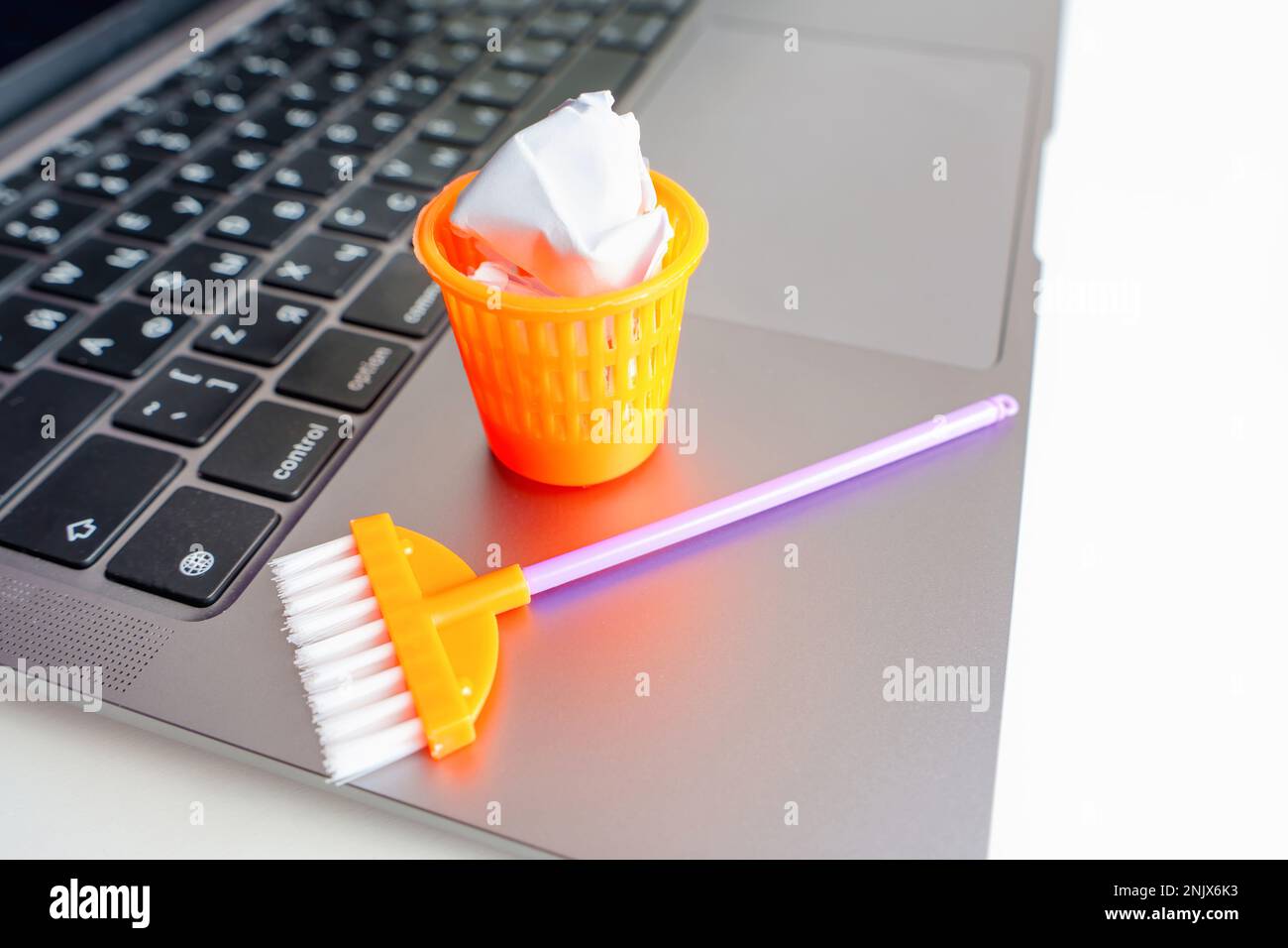 Concetto creativo di pulizia di polvere e detriti del computer: Spazzolone  giocattolo e rifiuti possono con palline di carta posizionate su un computer  portatile Foto stock - Alamy