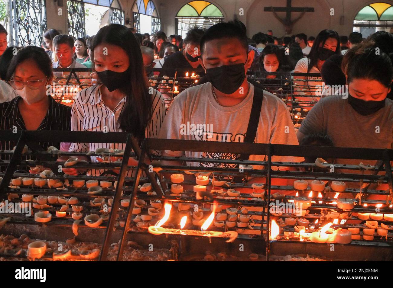 I devoti cattolici hanno visto pregare nella cappella delle candele della chiesa di Baclaran. I fedeli cattolici ricevono i segni di cenere della croce sulla loro fronte, nei terreni della Chiesa Redentorista (nota anche come Chiesa di Baclaran) nella città di Parañaque, Metro Manila. Segna l'inizio della Quaresima, il periodo quaresimale di 40 giorni nel calendario cattolico. È anche il momento del pentimento, della riflessione e del rinnovamento un migliore devoto cattolico. (Foto di Josefiel Rivera/SOPA Images/Sipa USA) Credit: Sipa USA/Alamy Live News Foto Stock