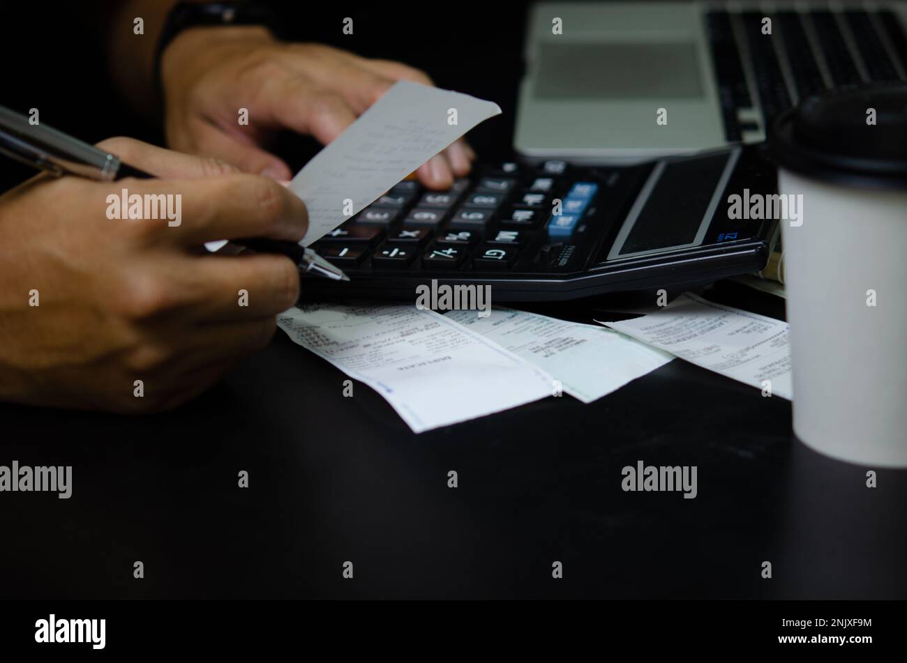 Uomo mano di tenuta fattura e penna con spese calcolatrice o ricevuta fiscale. concetto di finanza aziendale. Foto Stock