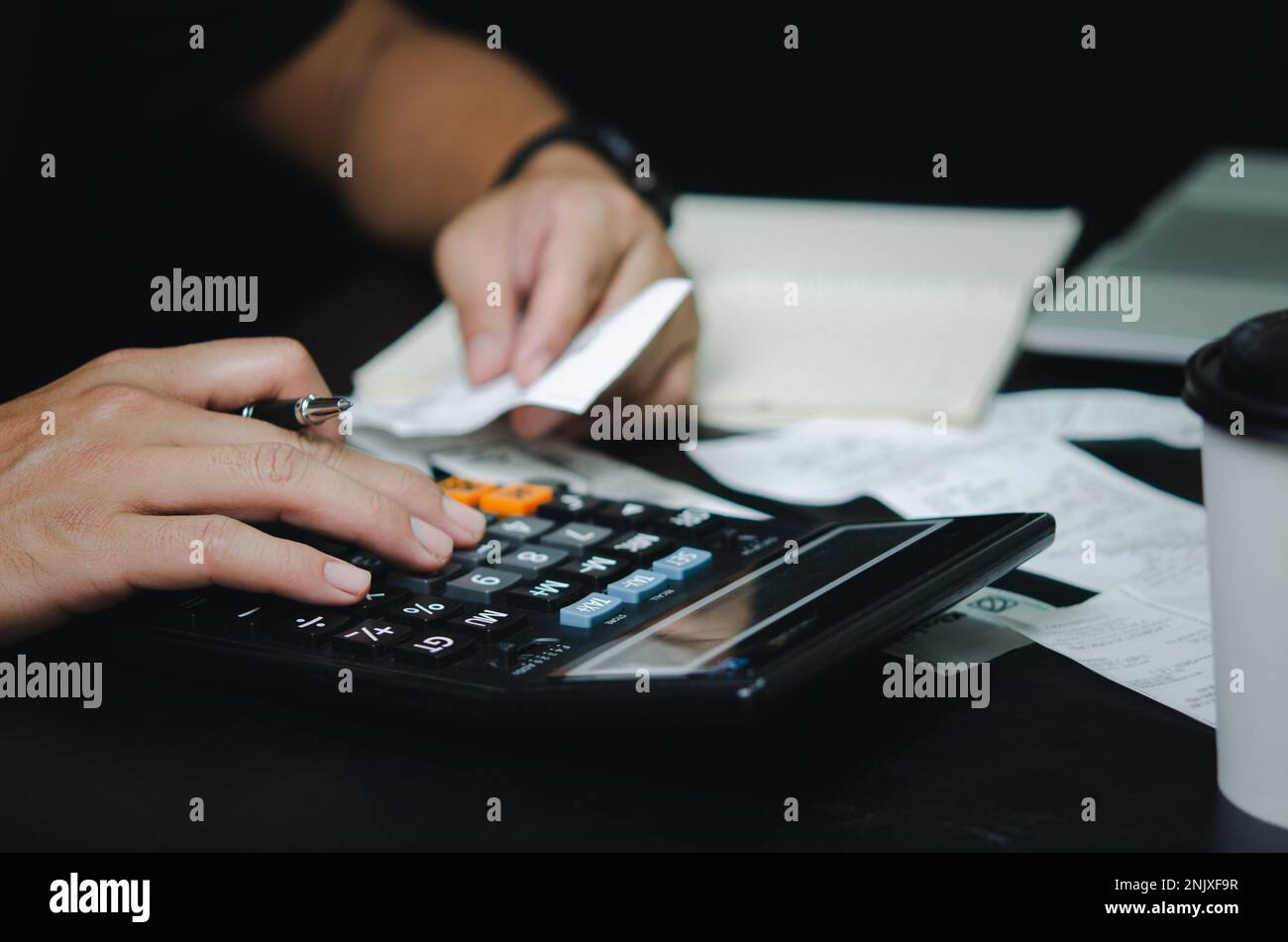 Uomo mano di tenuta fattura e penna con spese calcolatrice o ricevuta fiscale. concetto di finanza aziendale. Foto Stock