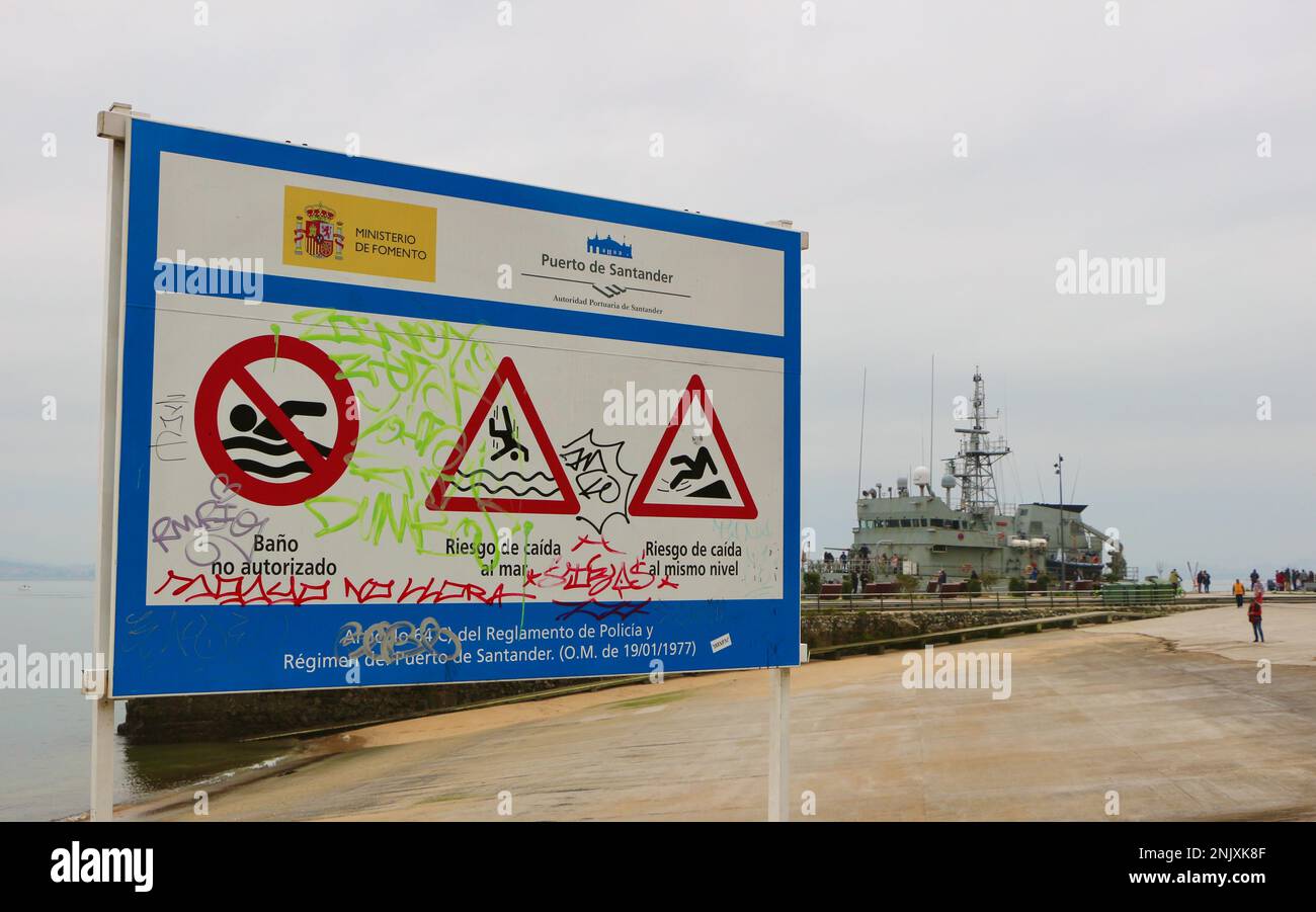 Segnale di pericolo al bordo delle acque vicino alla nave di pattuglia spagnola Servida P-71 ormeggiata nella zona portuale di Gamazo della Baia di Santander Cantabria Spagna Foto Stock