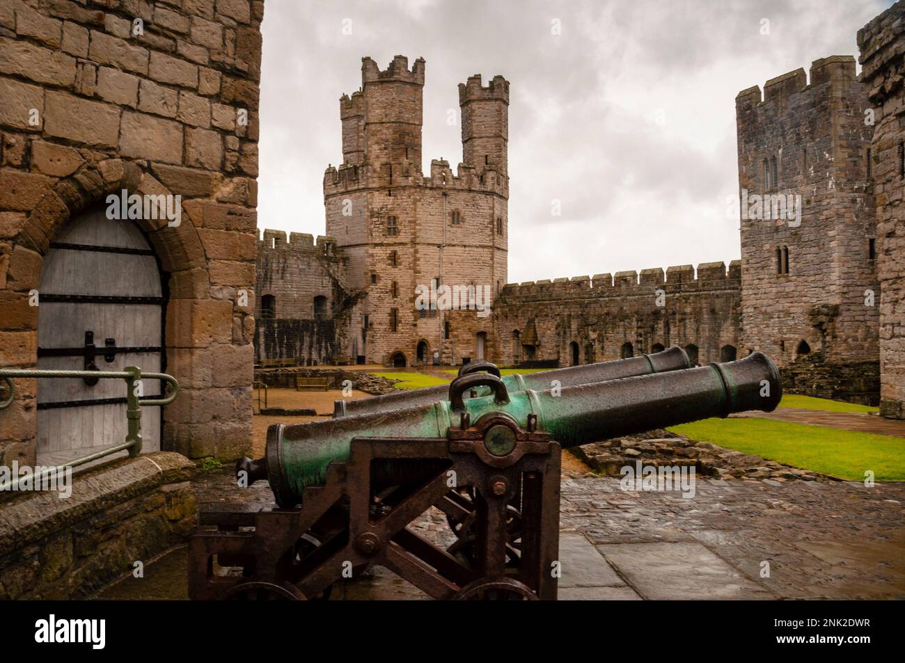 Coppia di cannoni, porta ad arco a punta e tre torrette della Eagle Tower al castello edoardiano di Caernarfon a Caernarfon, Galles. Foto Stock