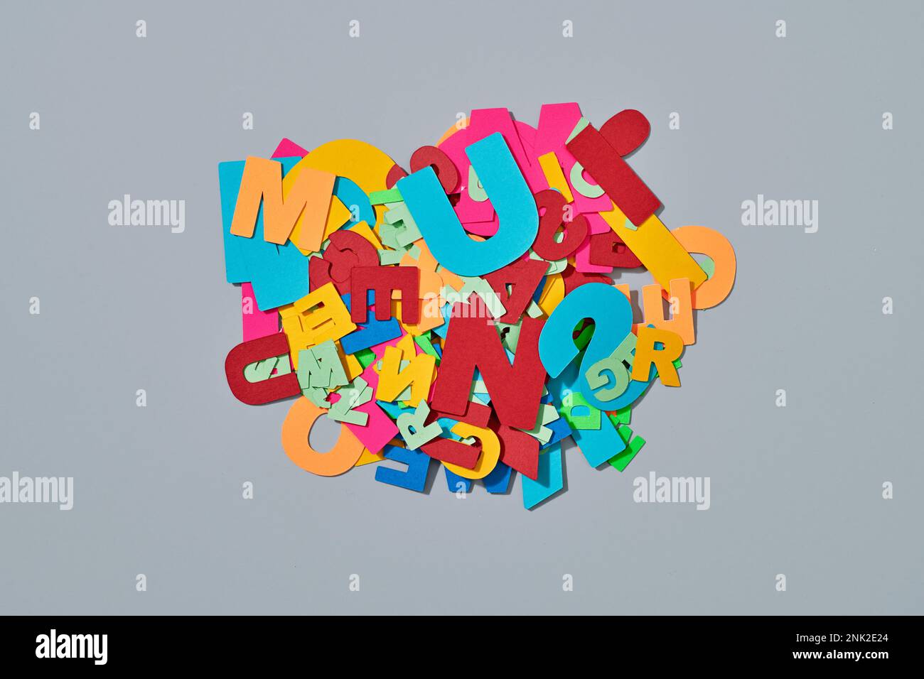 visualizzazione ad angolo elevato di un gruppo di lettere di carta di diversi colori e formati, su sfondo grigio Foto Stock