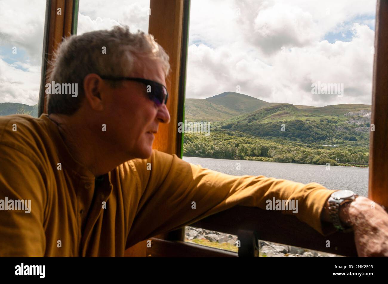 La Llanberis Lake Railway corre lungo la riva settentrionale di Llyn Pardarn, un lago glaciale del Galles. Foto Stock