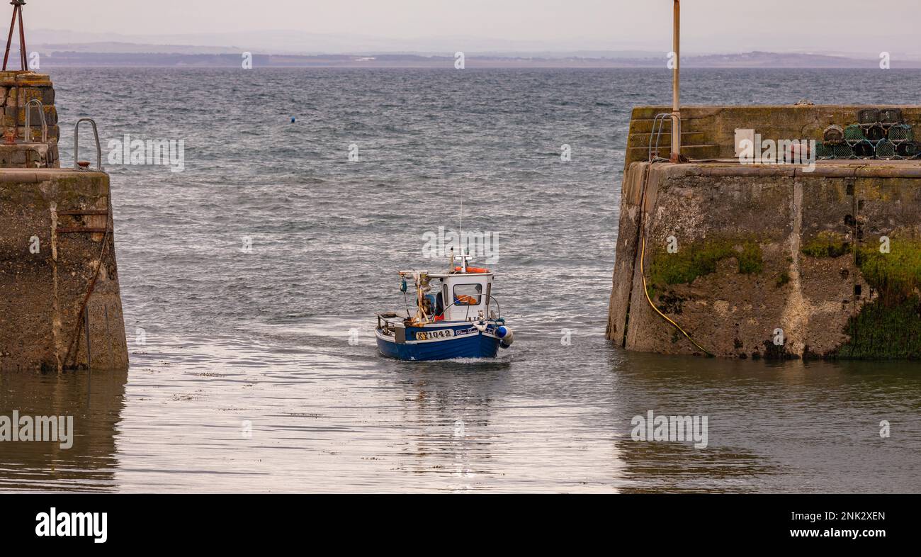 PORTO DI ST MONANS, FIFE, SCOZIA, EUROPA - una piccola imbarcazione commerciale entra nel porto di un antico villaggio di pescatori, a East Neuk. Foto Stock
