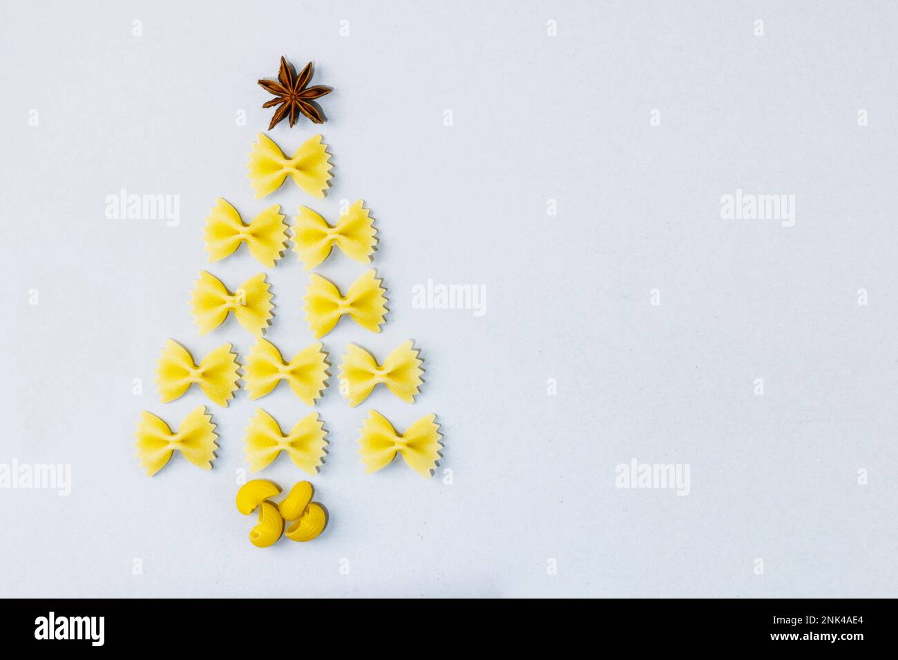 Albero di Natale creativo fatto di pasta su sfondo grigio. Il concetto di cucina creativa di Natale, la creatività dei bambini. Spazio di copia Foto Stock