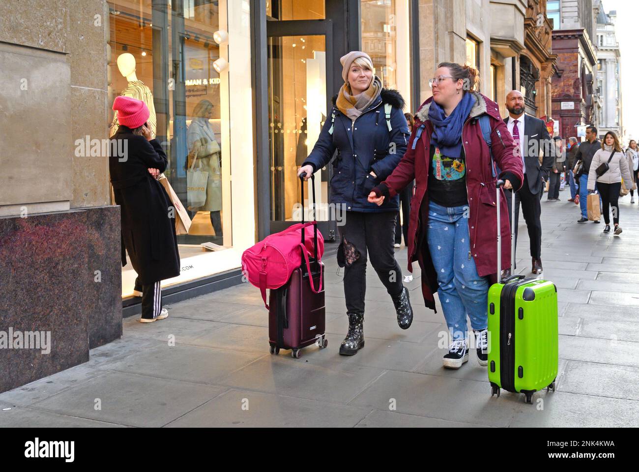 Londra, Inghilterra, Regno Unito. Due donne che fanno la ruota bagagli a Oxford Street Foto Stock
