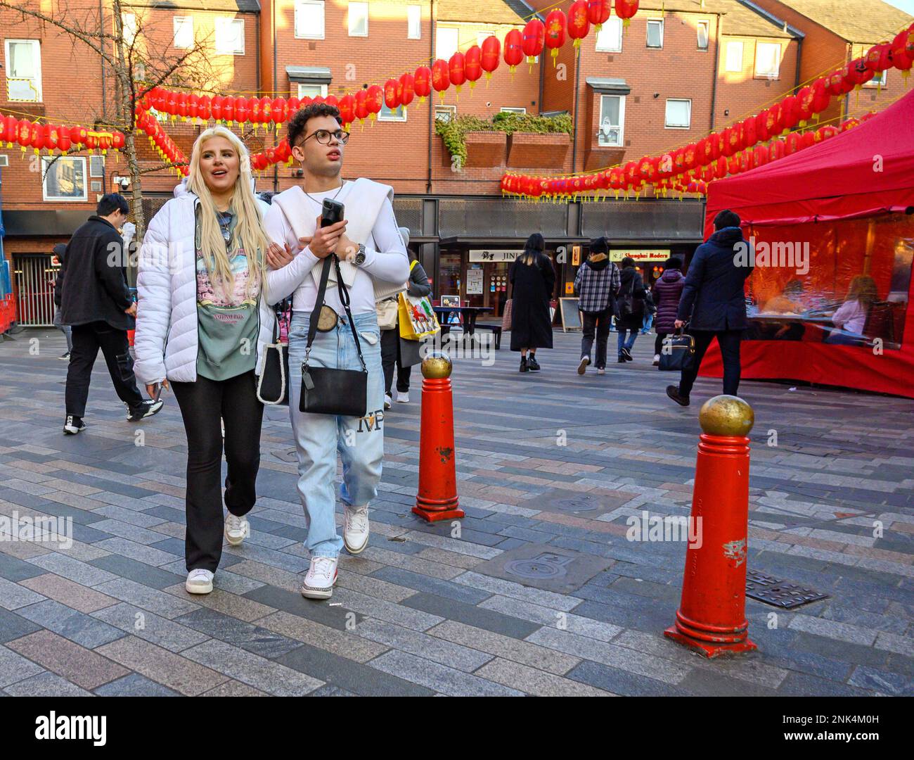 Londra, Inghilterra, Regno Unito. Coppia vestita di bianco a piedi attraverso Chinatown. Foto Stock