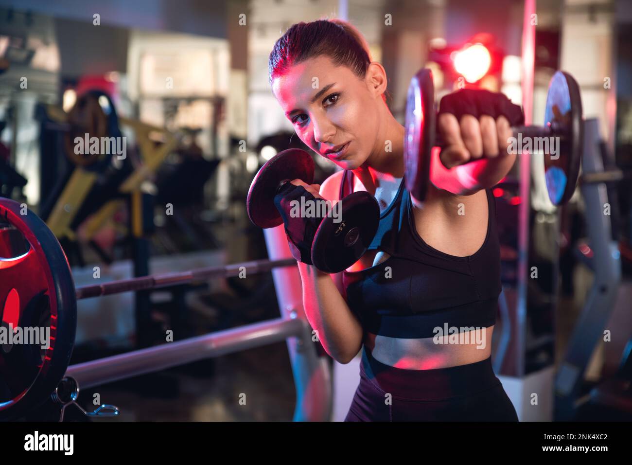 Ritratto di una donna che lavora con manubri in palestra. Foto Stock