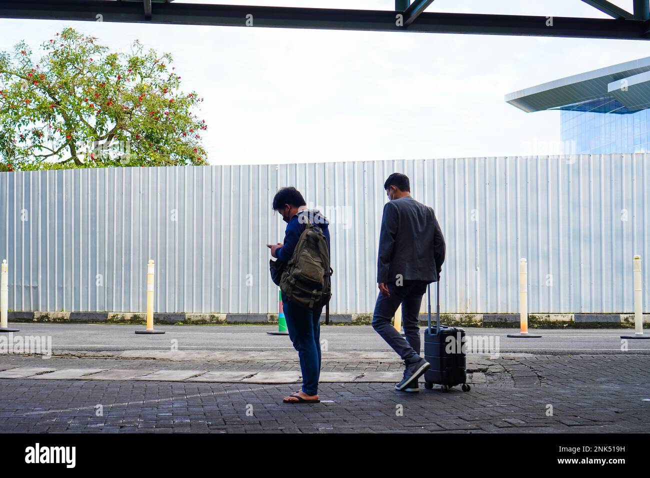 Backpacker dan Traveller. Man's esce dal terminal dell'aeroporto Foto Stock