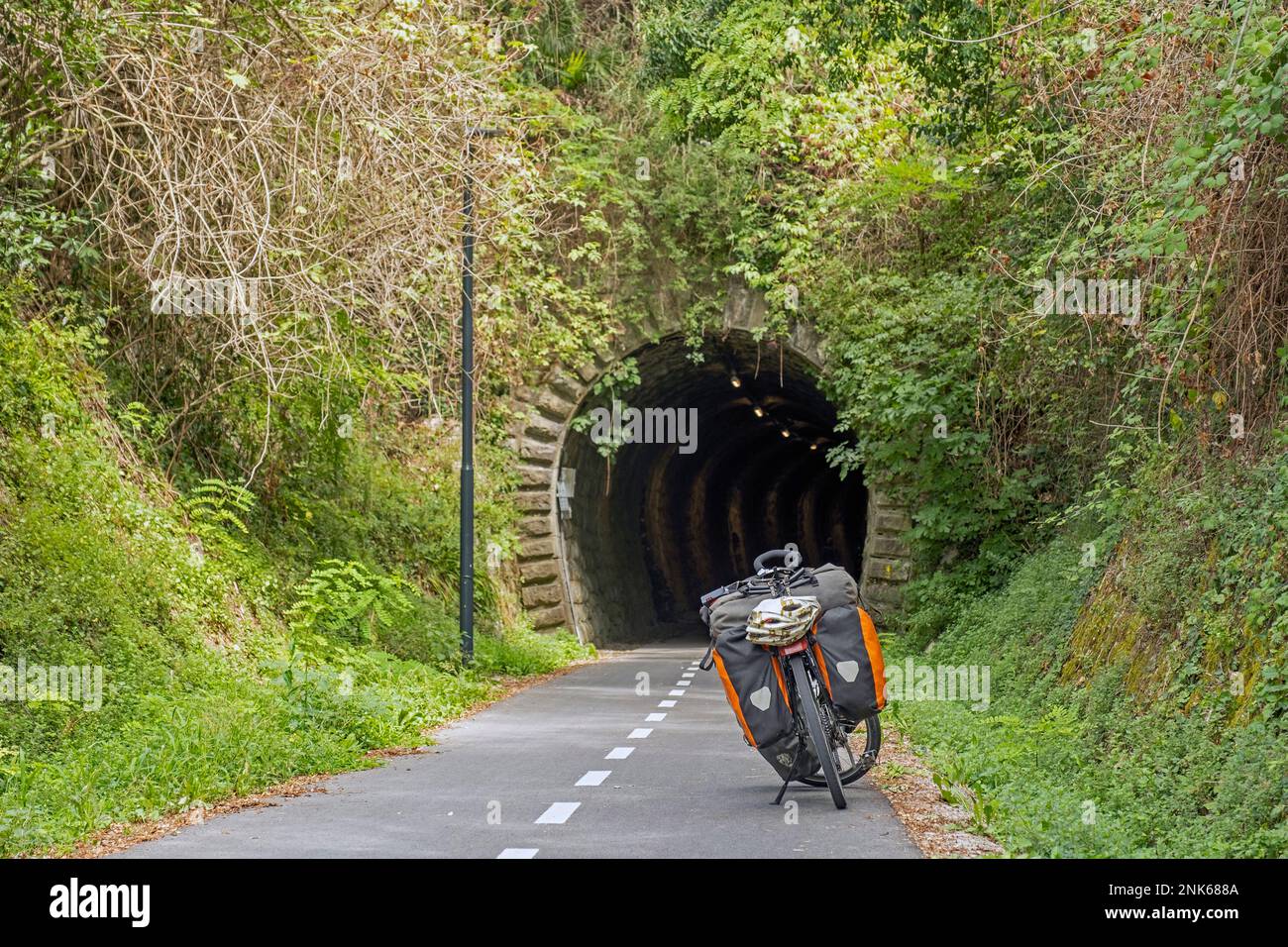 Bici da trekking di fronte al vecchio tunnel ferroviario sulla pista ciclabile Parenzana in Slovenia che va da Muggia, Italia a Poreč, Croazia Foto Stock