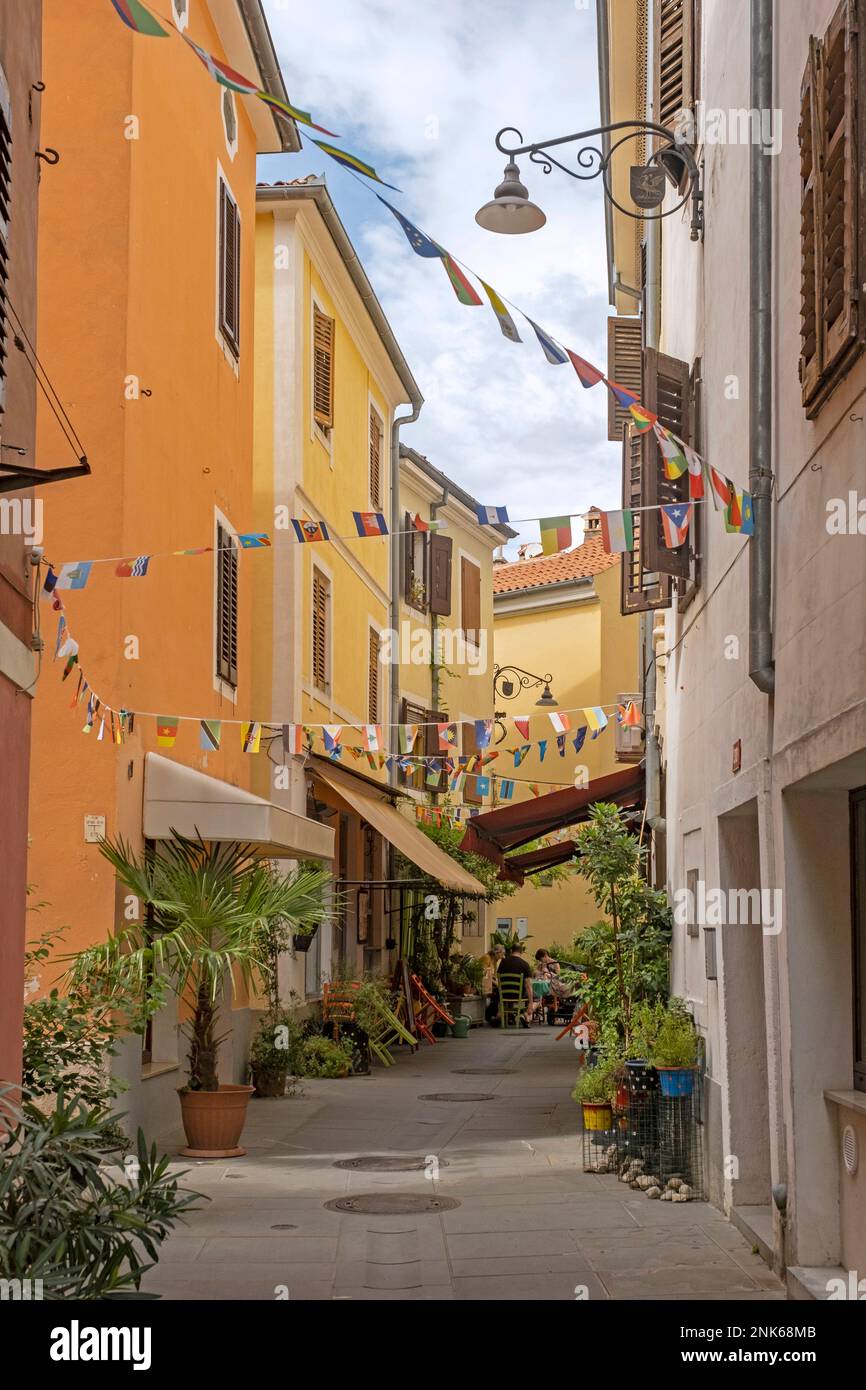 Vicolo color pastello con ristoranti nella città di Izola / Isola lungo la costa adriatica, Coastal–Carst / Obalnokraška, Littoral / Primorska, Slovenia Foto Stock
